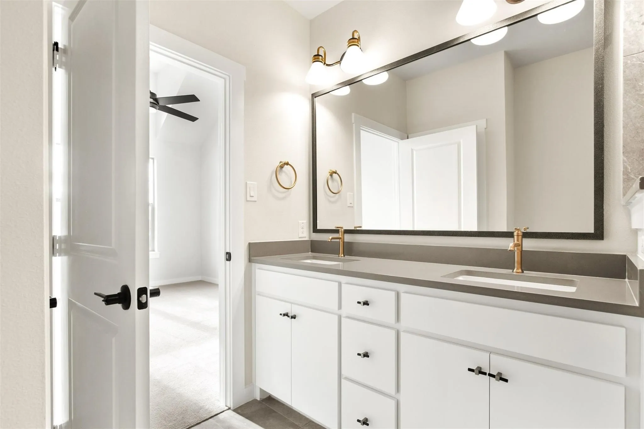 Full bathroom featuring double vanity and baseboards