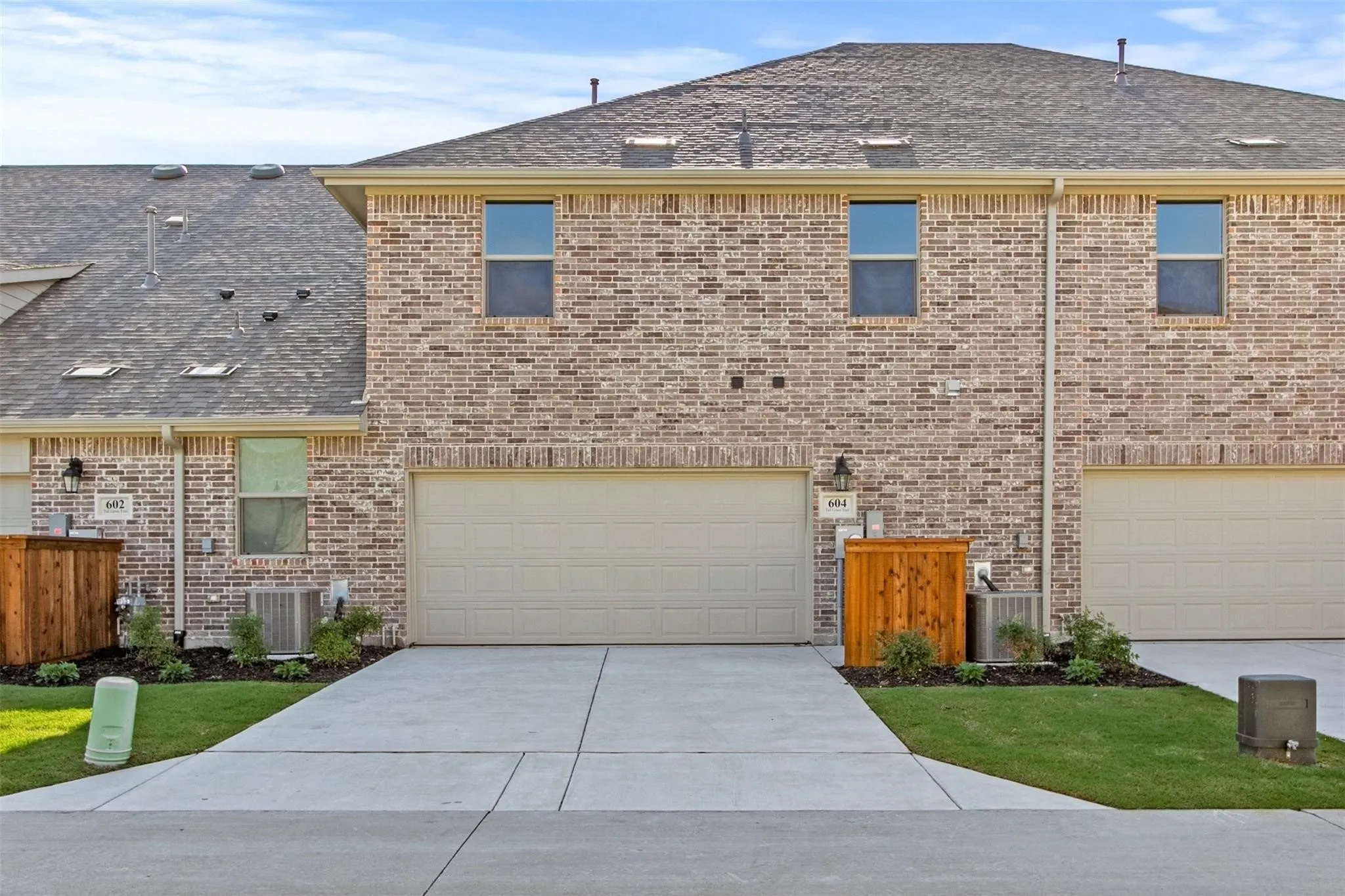 View of front of property featuring driveway, an attached garage, and brick siding