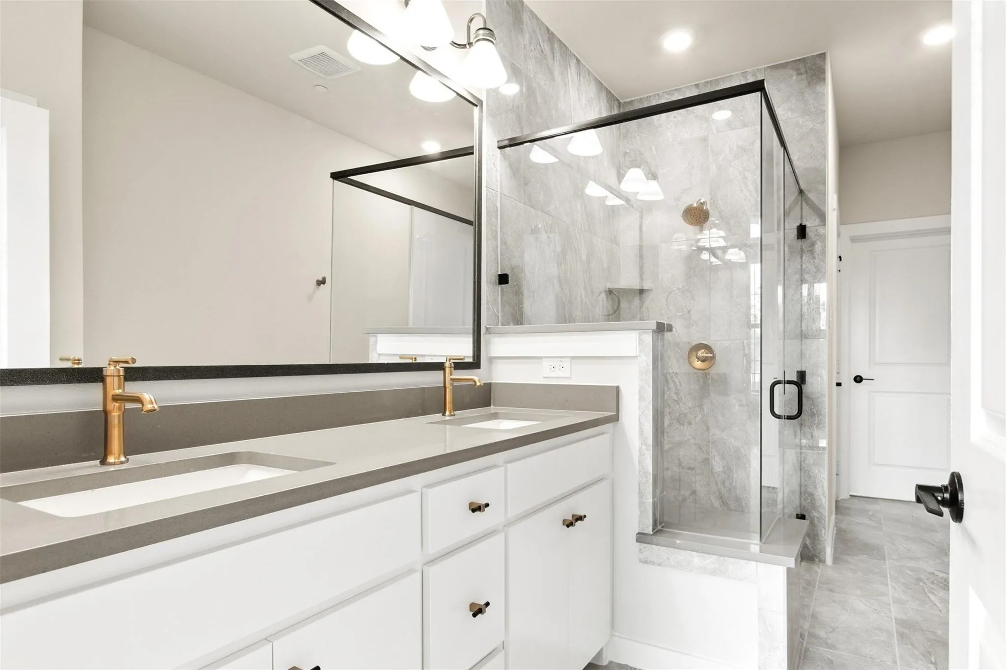 Full bathroom featuring double vanity, a stall shower, and recessed lighting
