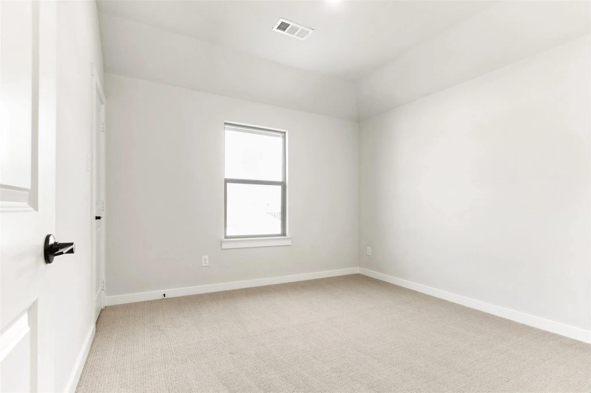 Spare room with light carpet and baseboards