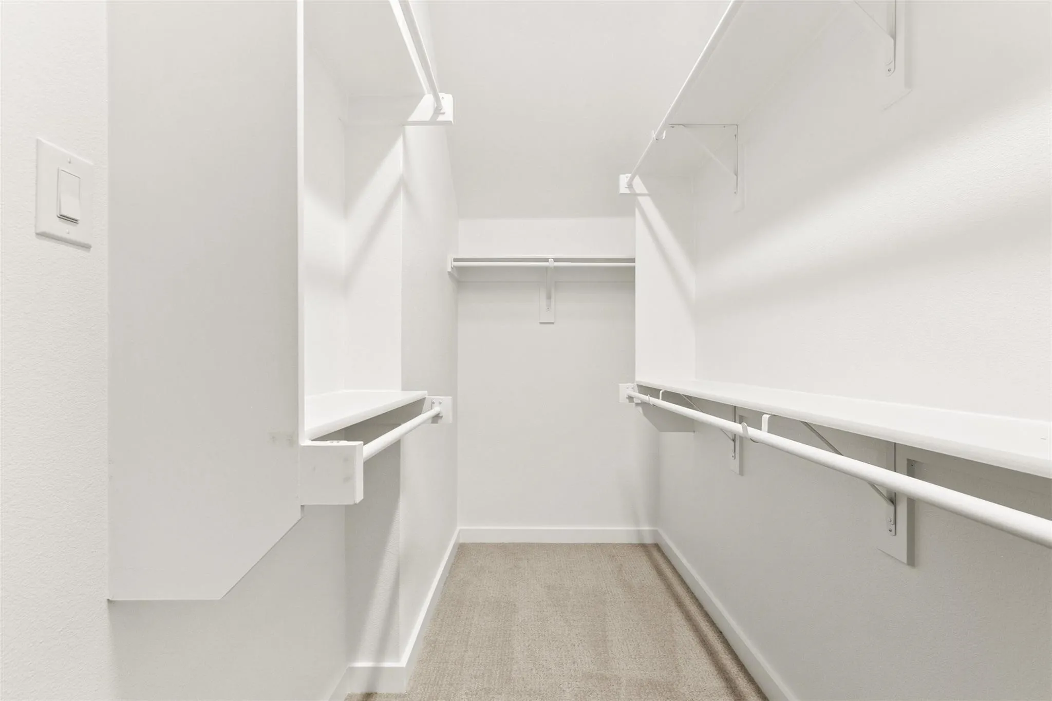 Walk in closet featuring light colored carpet
