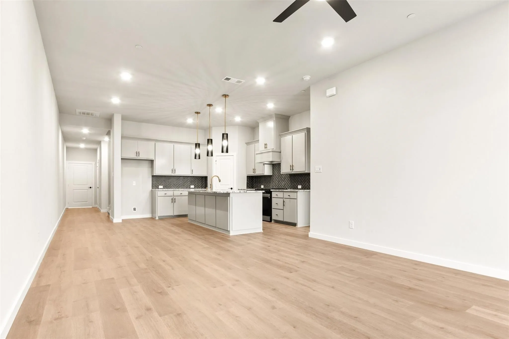 Unfurnished living room featuring ceiling fan, recessed lighting, and light wood-style floors