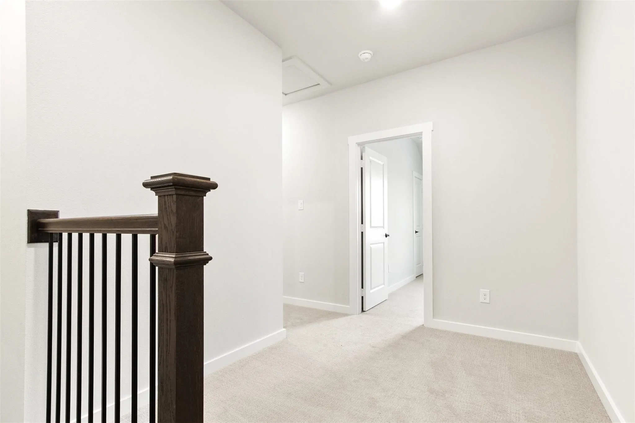 Hall with light carpet and an upstairs landing