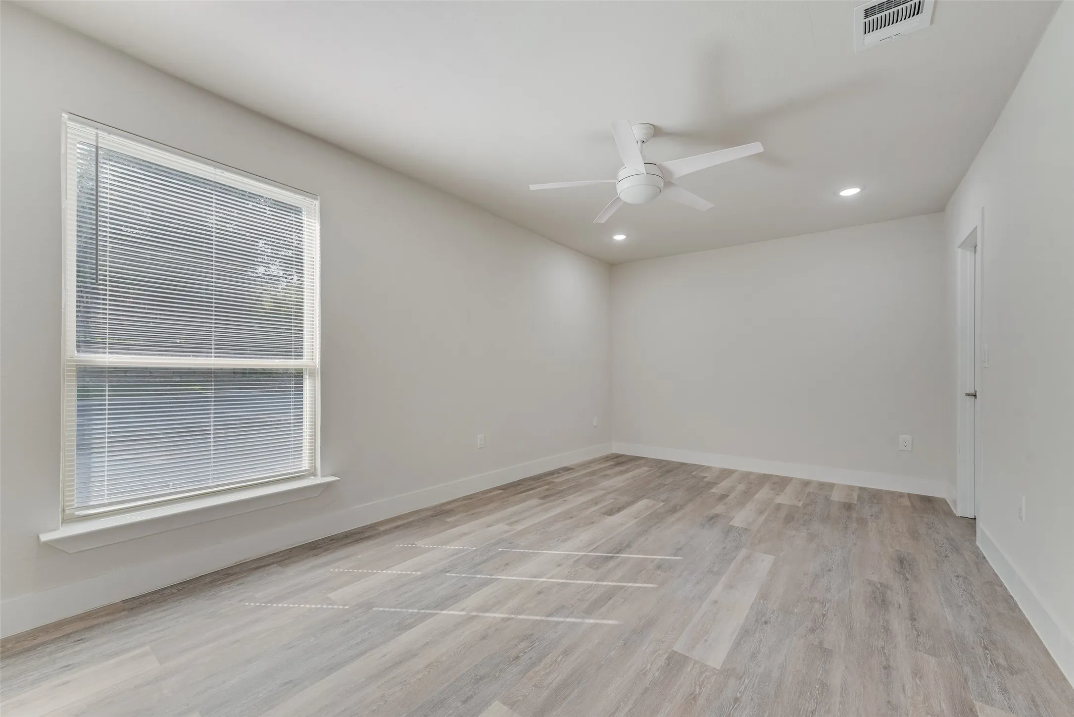 Bright interior with wood-finish flooring, recessed lighting, and a modern ceiling fan