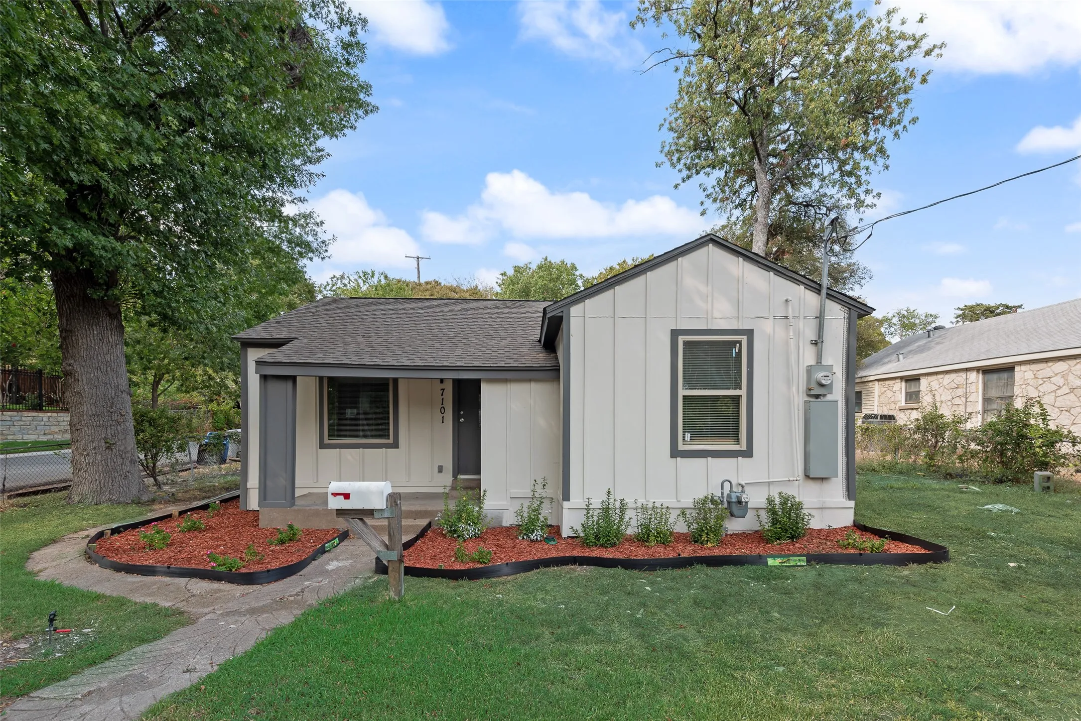 Single-story residence featuring a gabled roof and light-colored siding