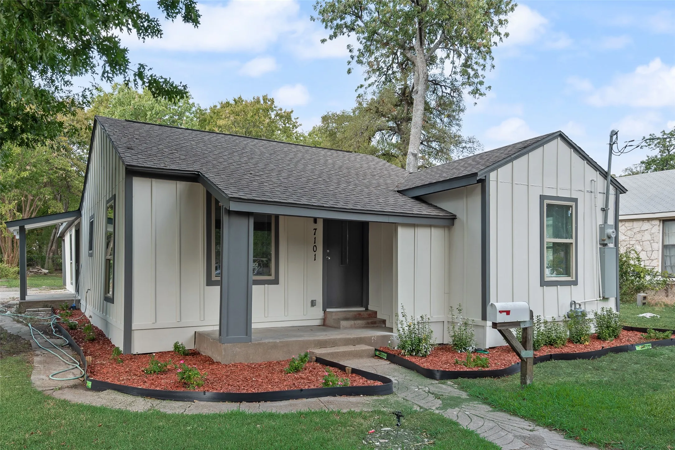 White vertical siding exterior with dark trim