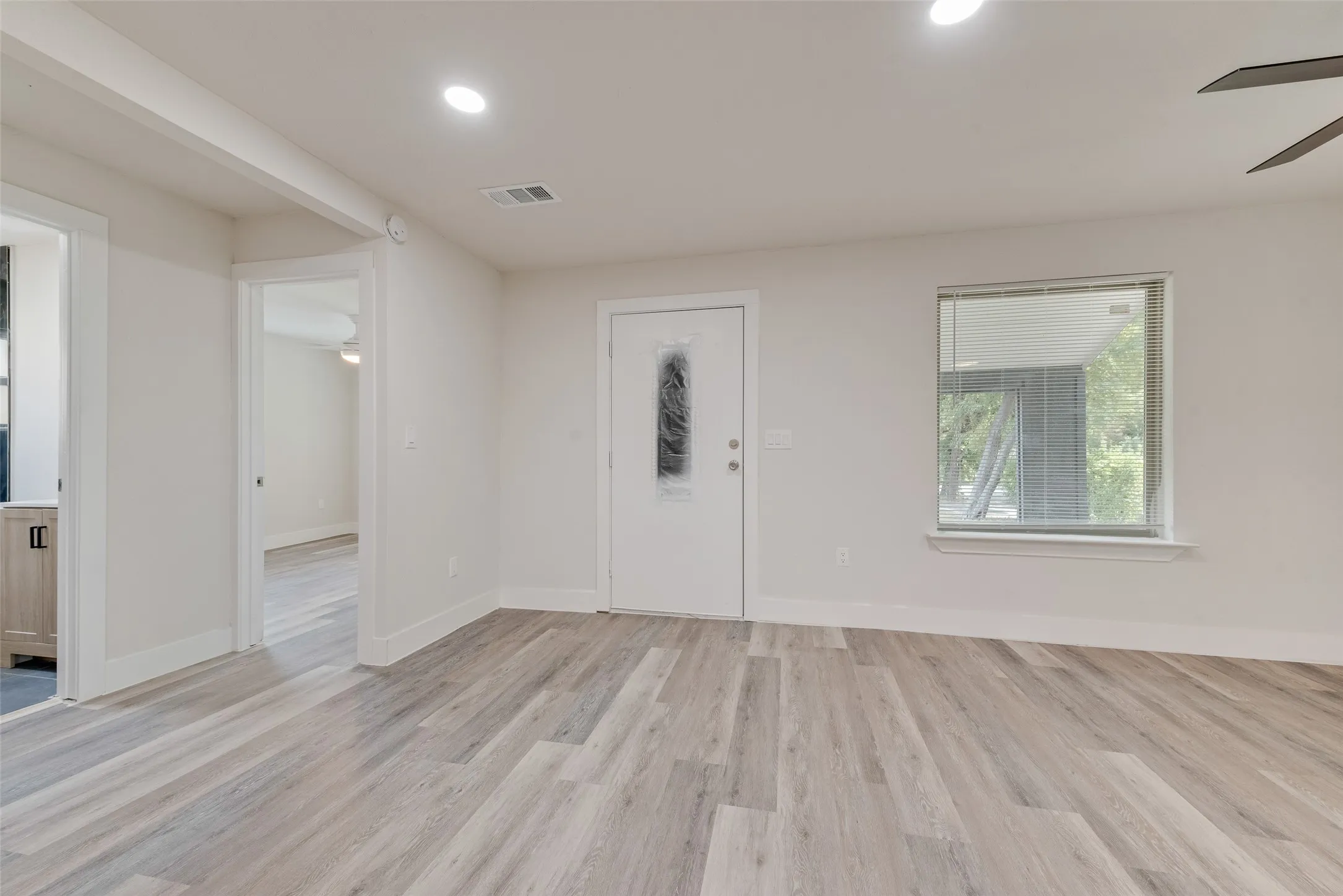 Wood-finish flooring throughout, recessed lighting, and a ceiling fan