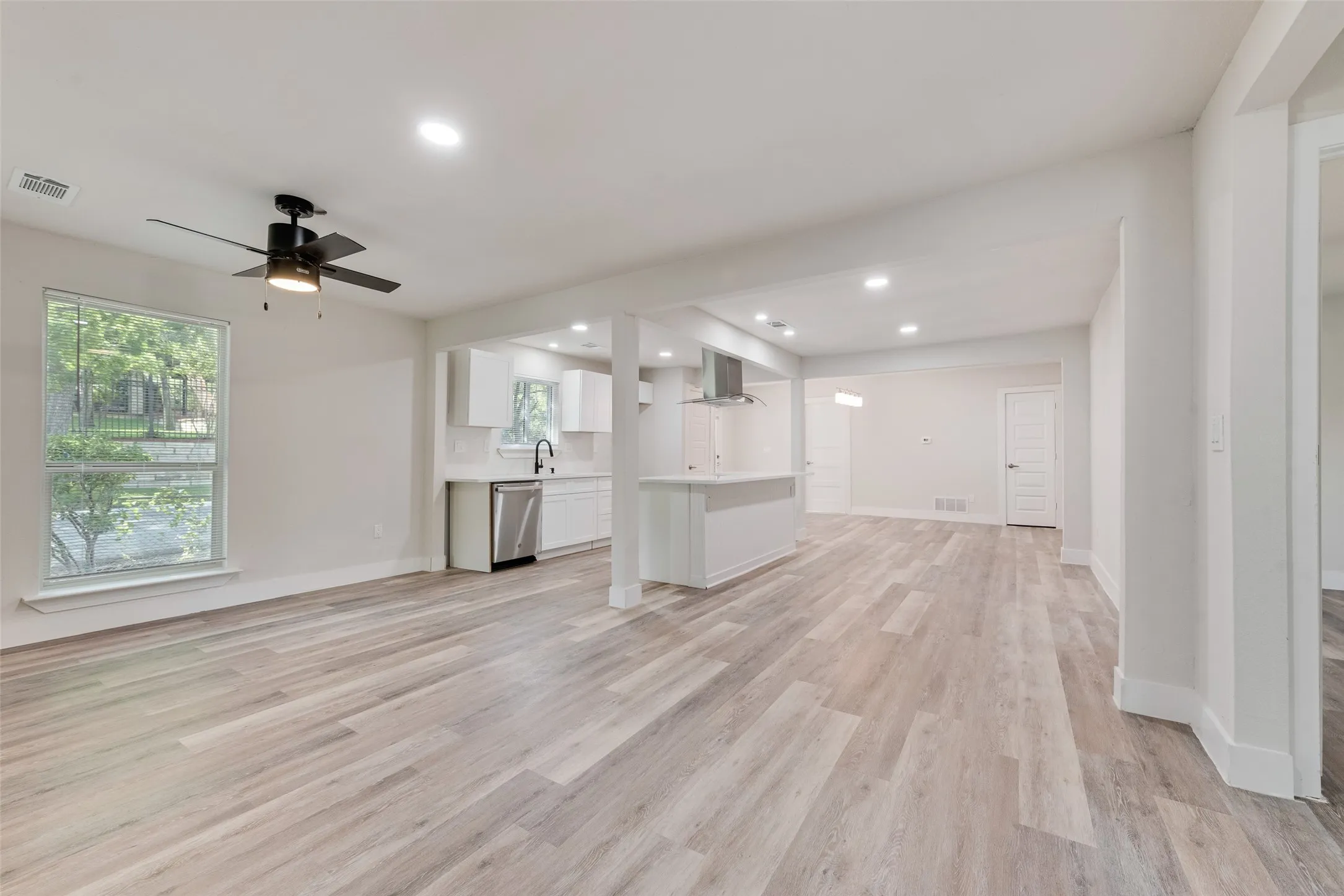 Expansive interior with wood-finish flooring, recessed lighting, and a modern ceiling fan