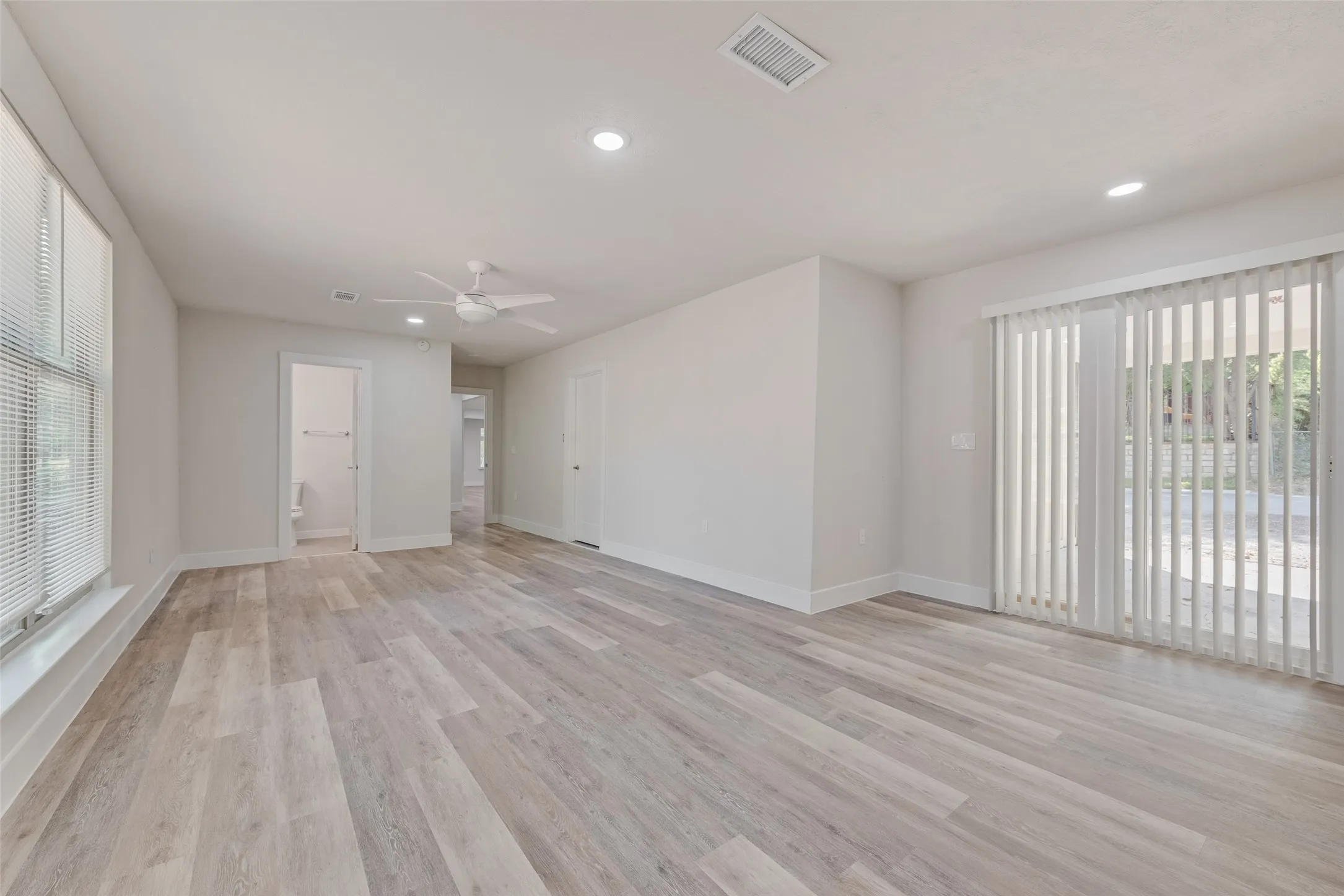 Recessed lighting, ceiling fan, wood-finish flooring, sliding glass door, and window with horizontal blinds