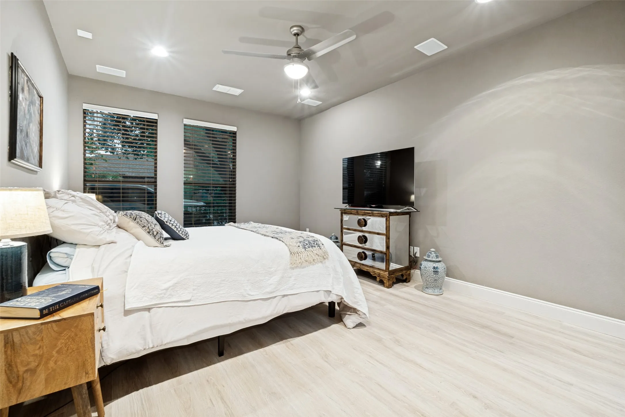 First floor primary with new floors and baseboards, floor to ceiling windows and can lights