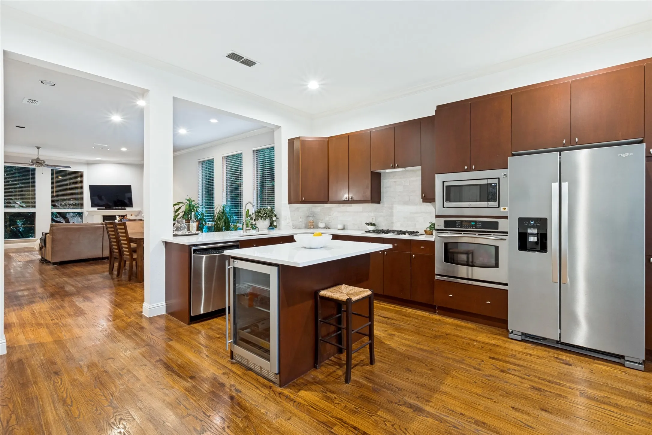 SS appliances and built-in wine fridge and additional seating at the island