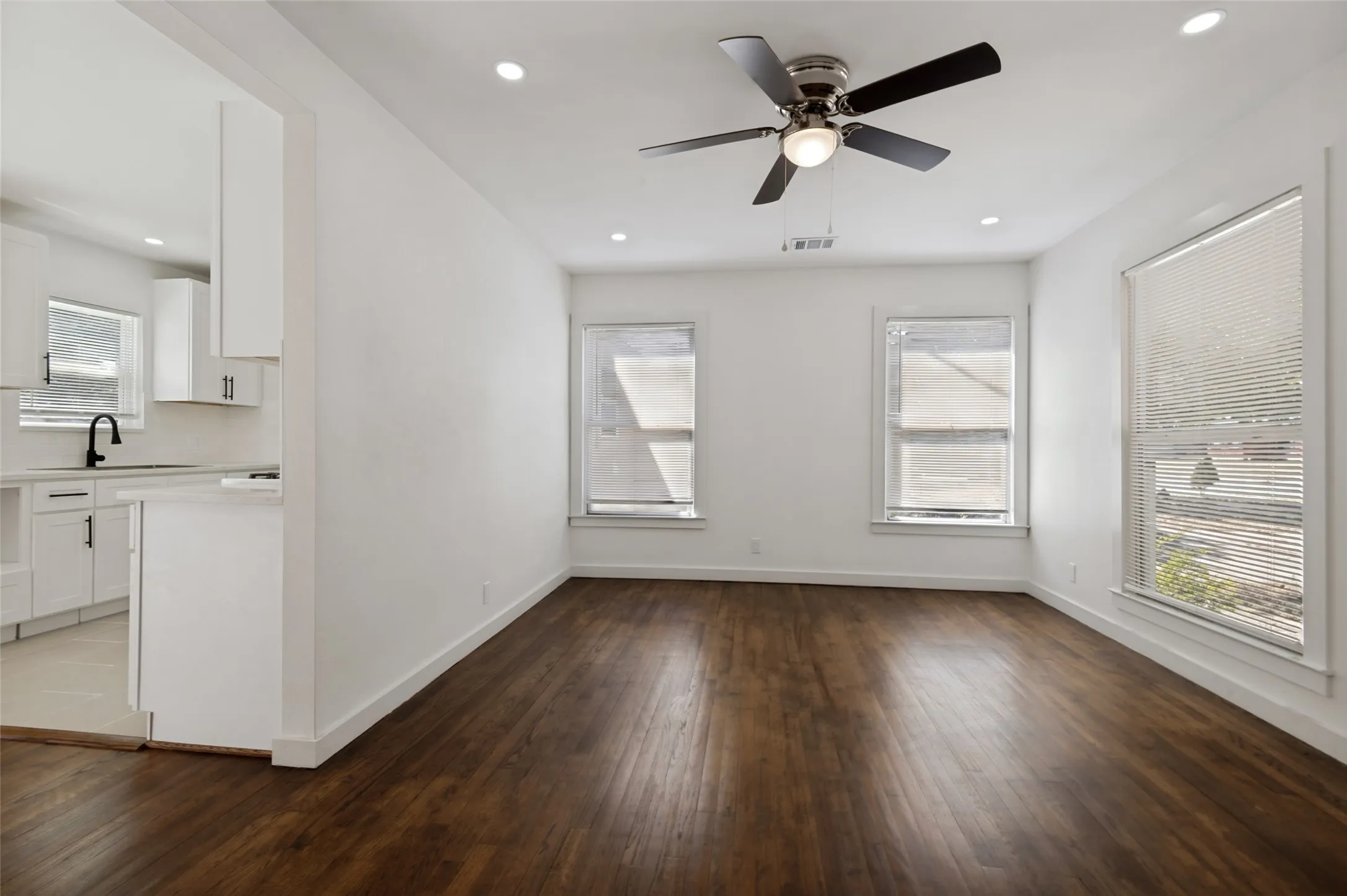 Wood-finish flooring, recessed lighting, and a ceiling fan with light fixture
