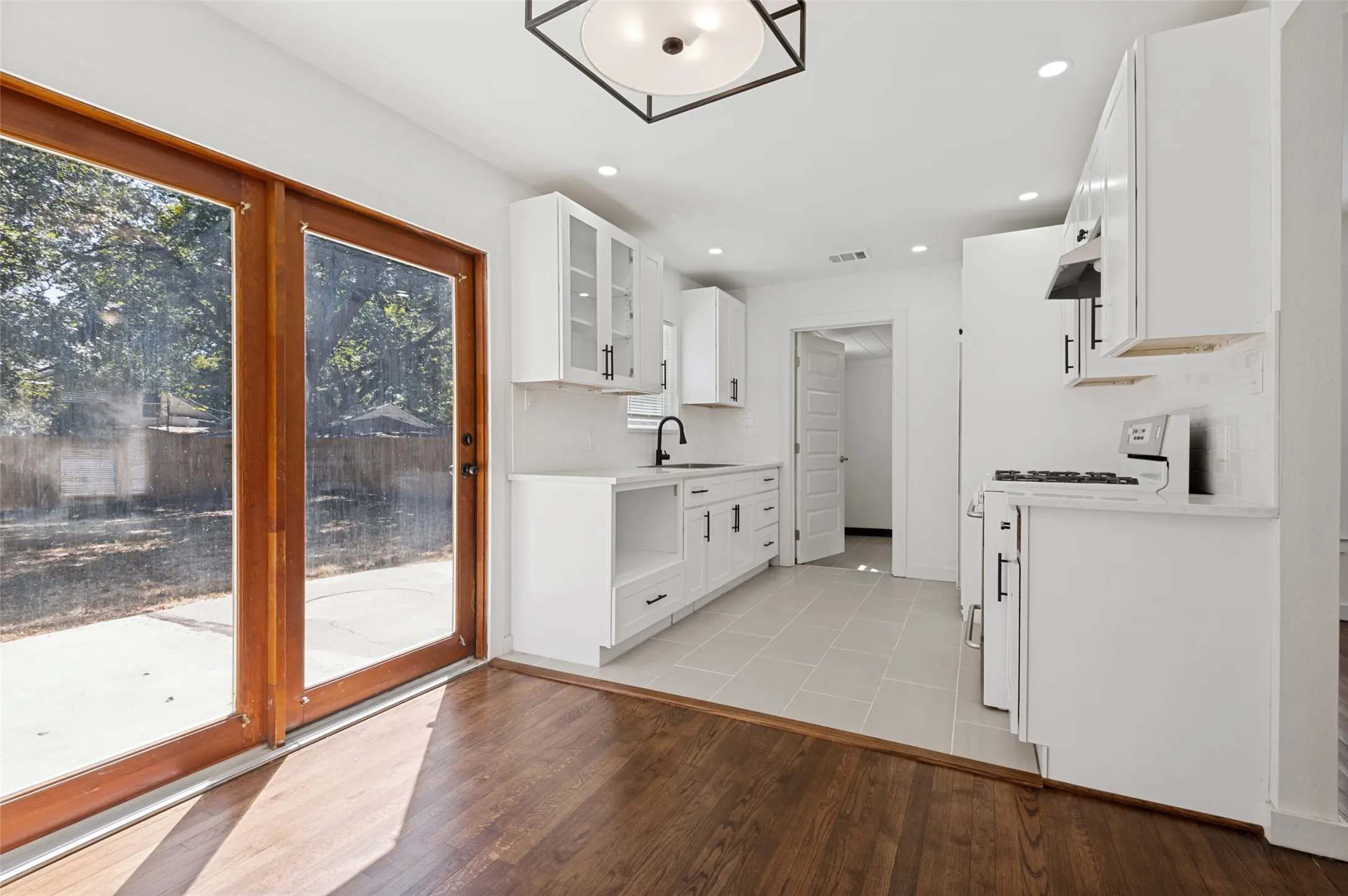 Contemporary kitchen with white cabinetry, stainless steel appliances, and tile flooring