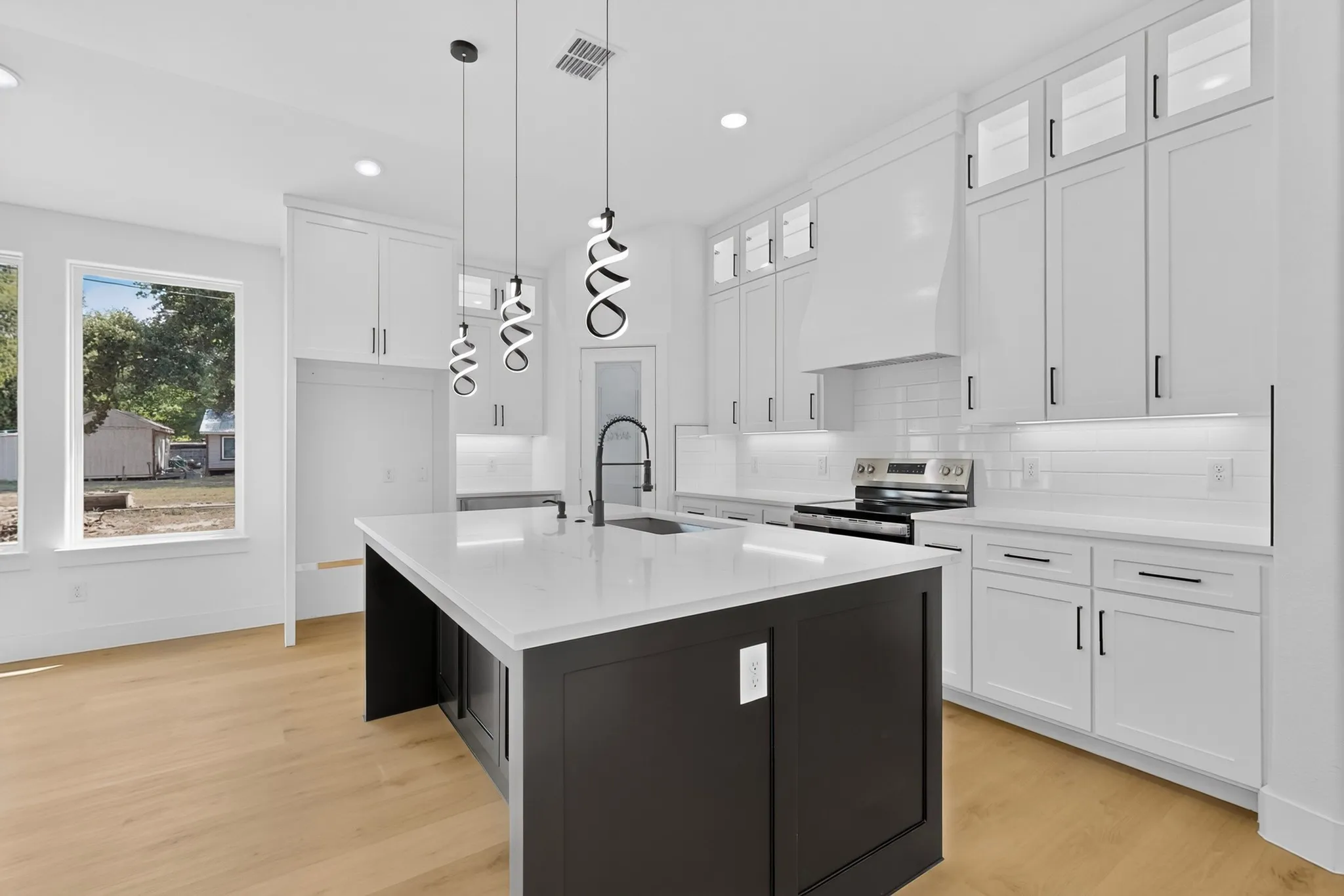 Spacious kitchen with large island, white cabinetry and modern finishes