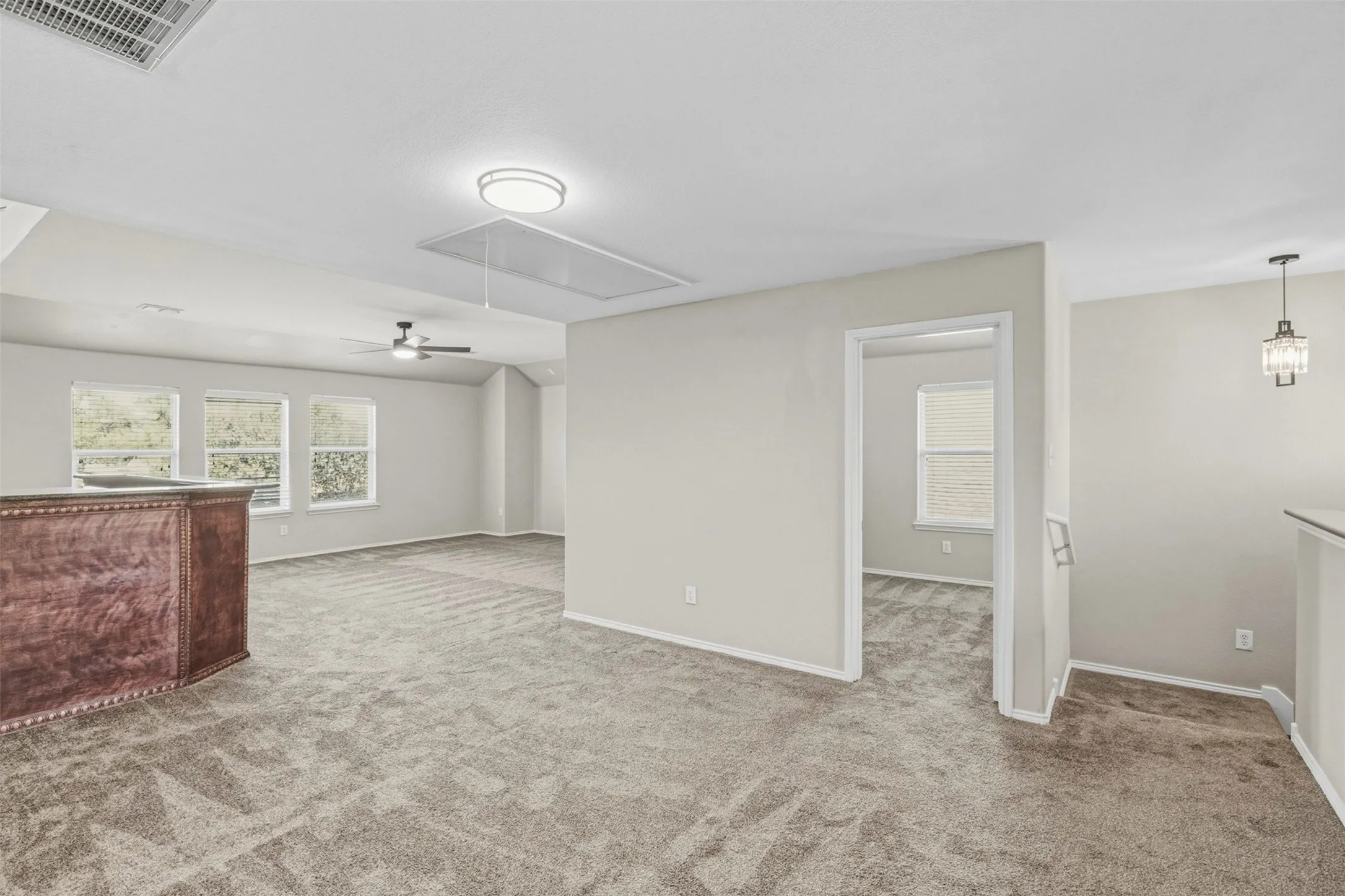 Carpeted open area with light gray walls