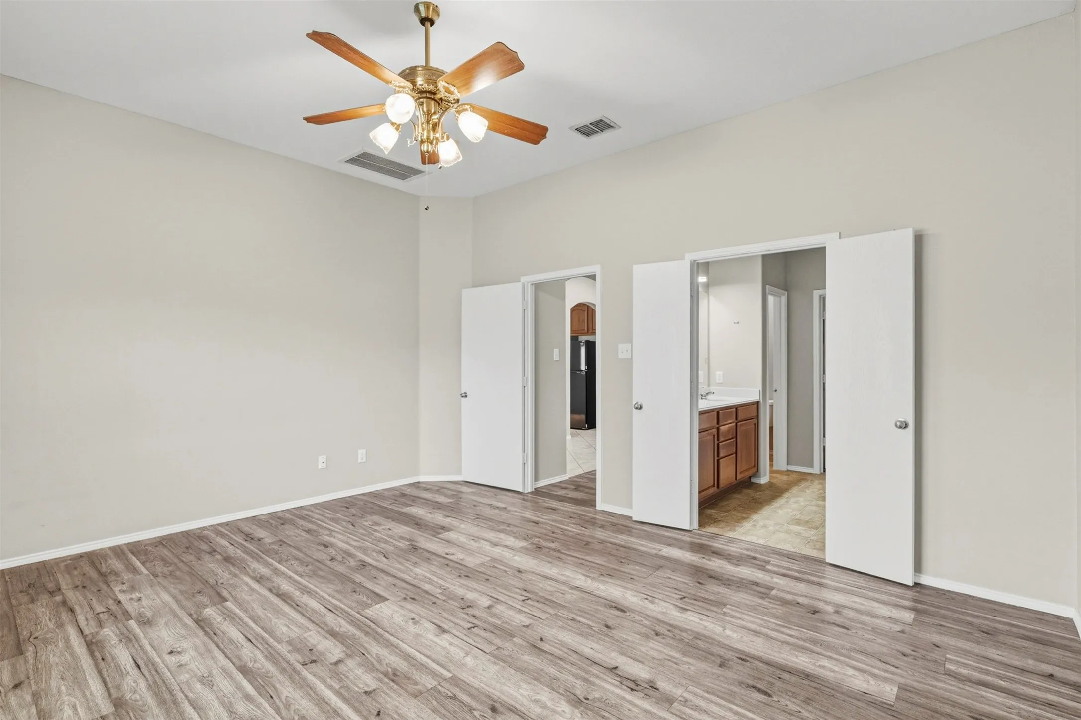 Wood-finish flooring throughout, neutral wall tones, and ceiling fan with integrated lighting
