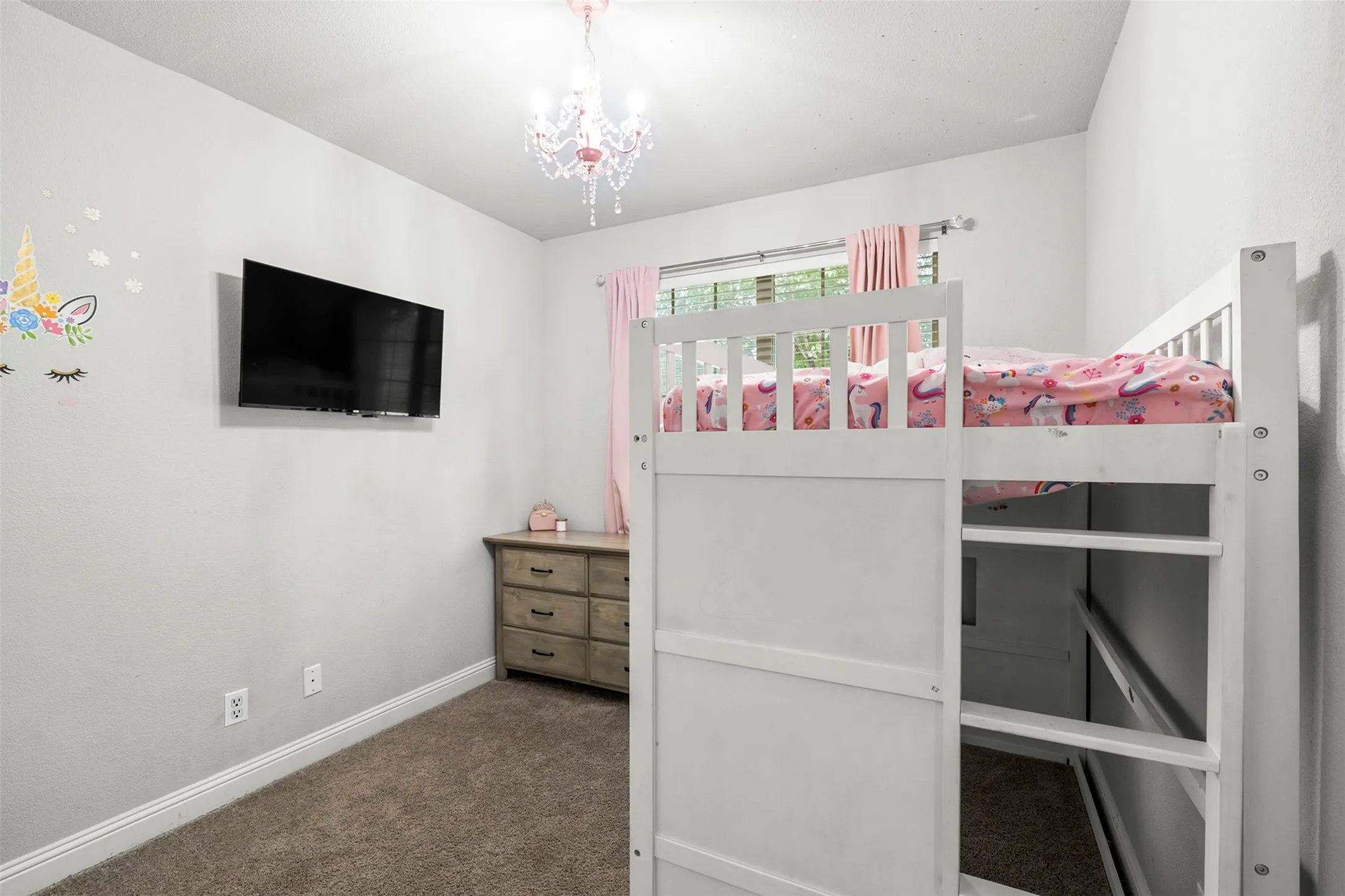 Recessed window with drapes, wall-mounted television, built-in loft bed frame with ladder, and a decorative chandelier