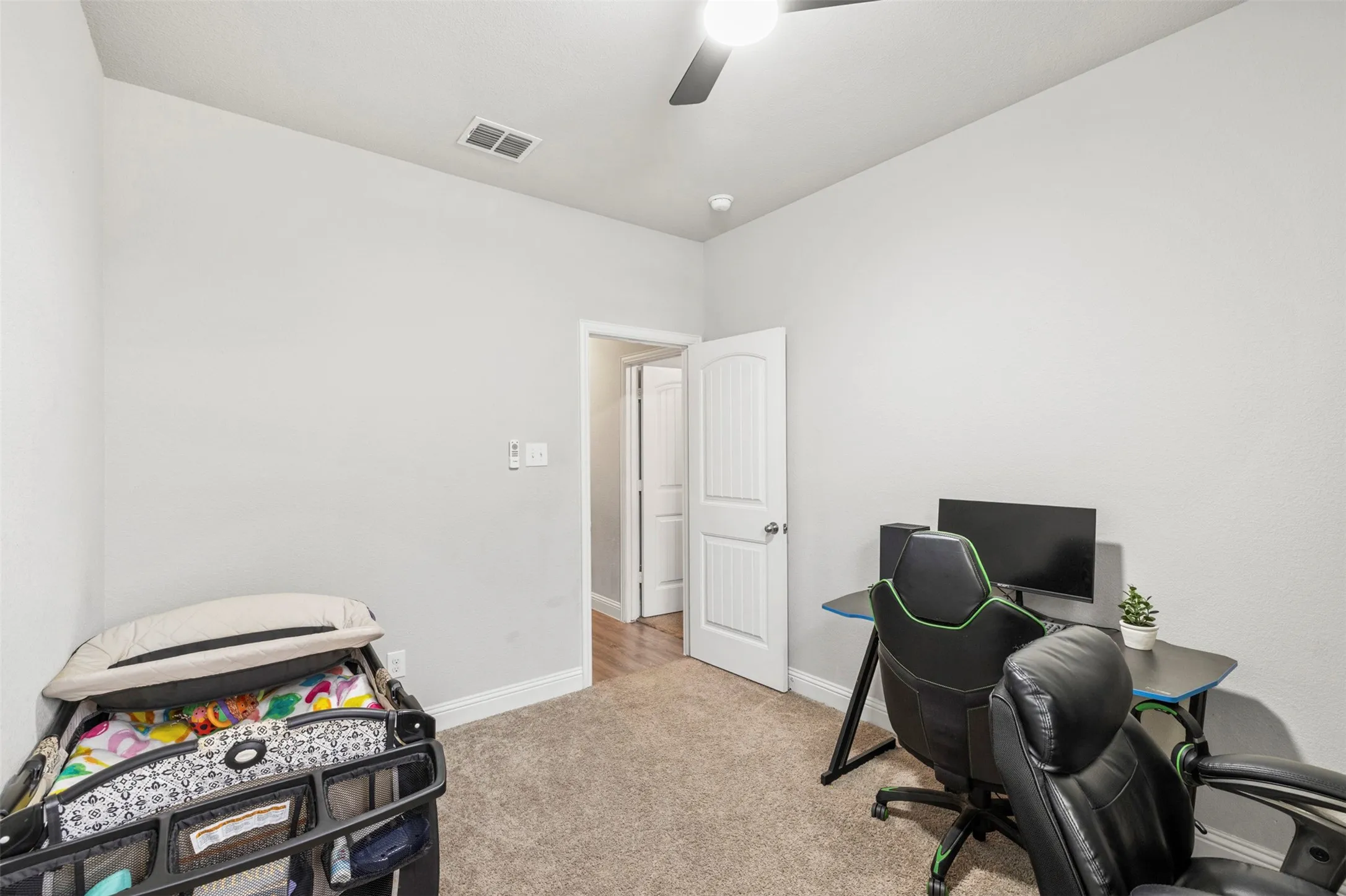 Carpeted room featuring a ceiling fan with integrated lighting, a white paneled door, and recessed lighting
