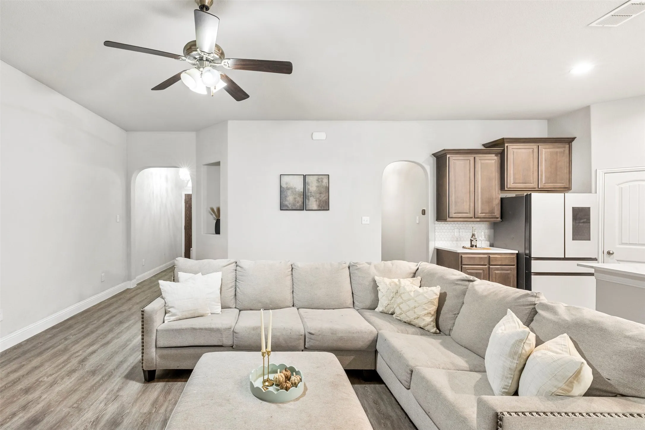 Wood-finish flooring throughout, recessed lighting, ceiling fan, arched doorways, and built-in cabinetry