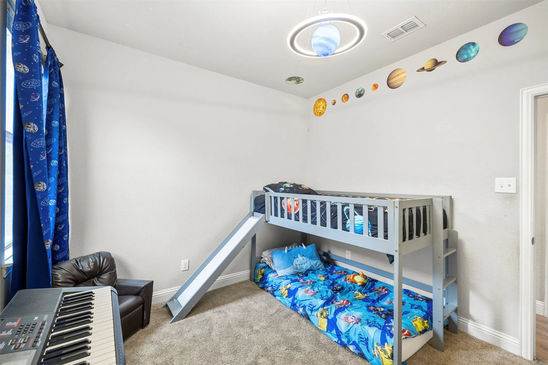 Carpeted bedroom with a bunk bed frame, white walls, and a ceiling-mounted light fixture
