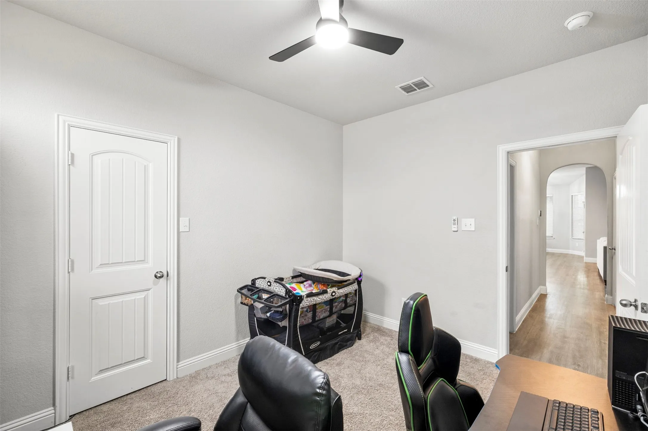 Carpet flooring, ceiling fan, arched doorway, and white interior doors