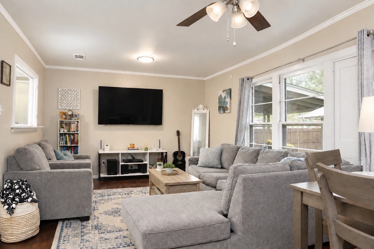 Living area featuring wood-finish flooring, a ceiling fan with integrated lighting, recessed lighting, and multiple windows