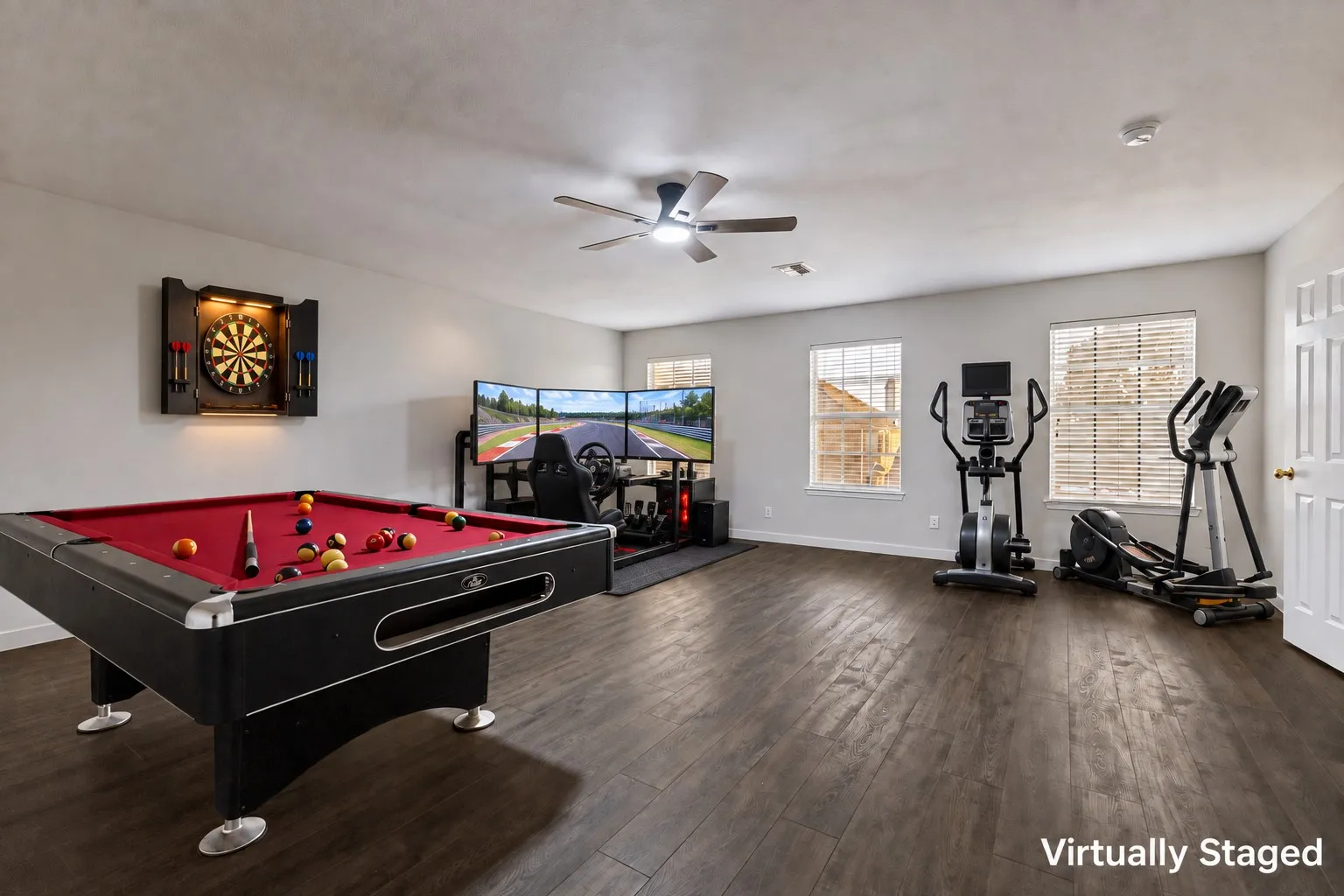 Spacious room featuring a pool table, wood-finish flooring, three windows with blinds, and a ceiling fan with integrated lighting