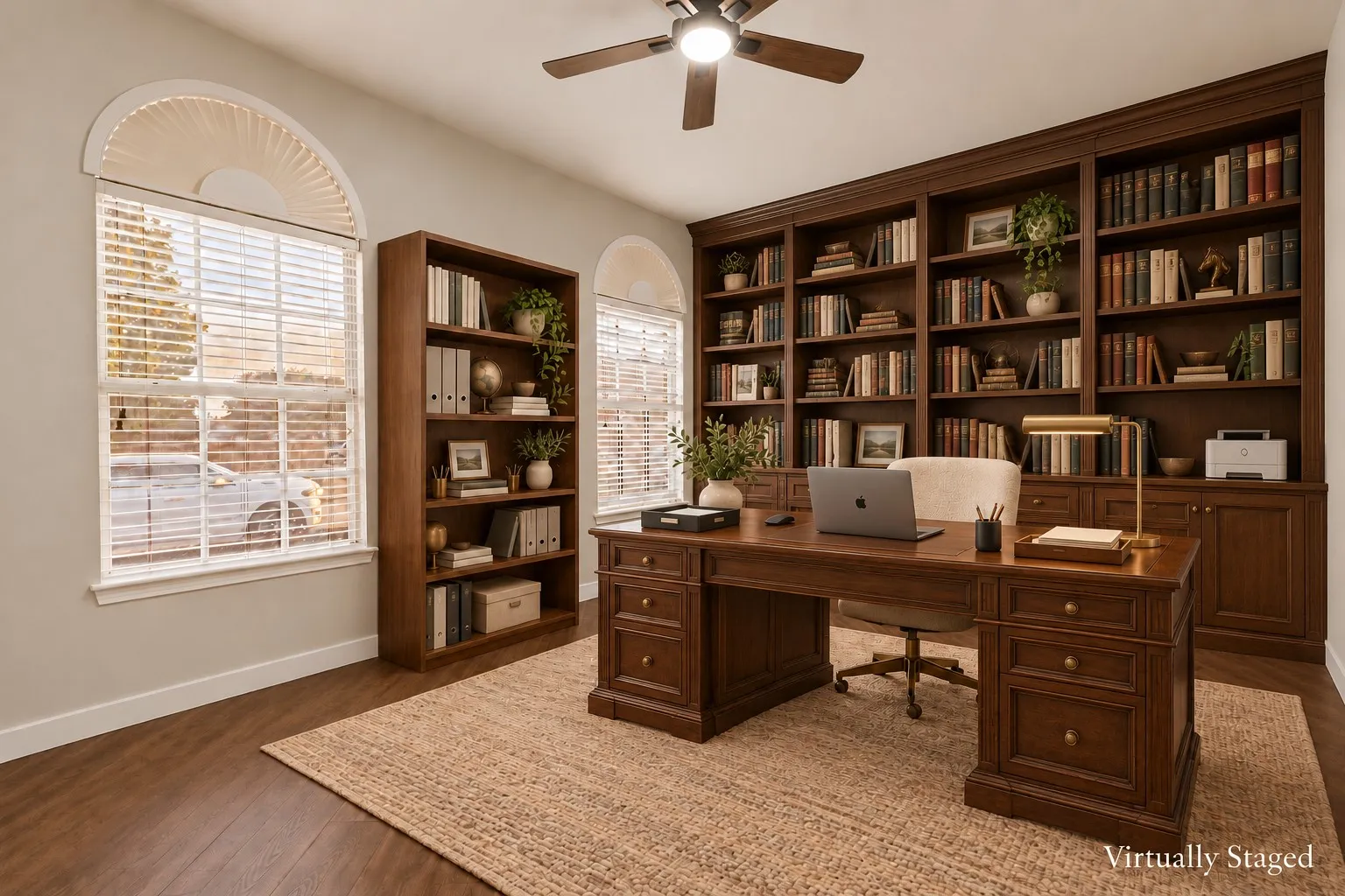 Wood-finish flooring, two large windows with arched transoms, and a ceiling fan with integrated lighting