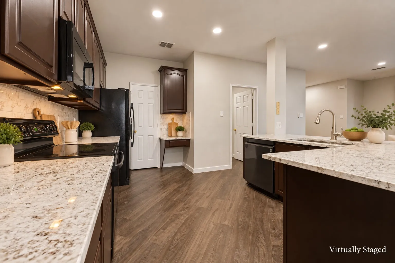 Kitchen featuring wood-finish flooring, dark wood cabinetry, light-toned countertops, and recessed ceiling lighting