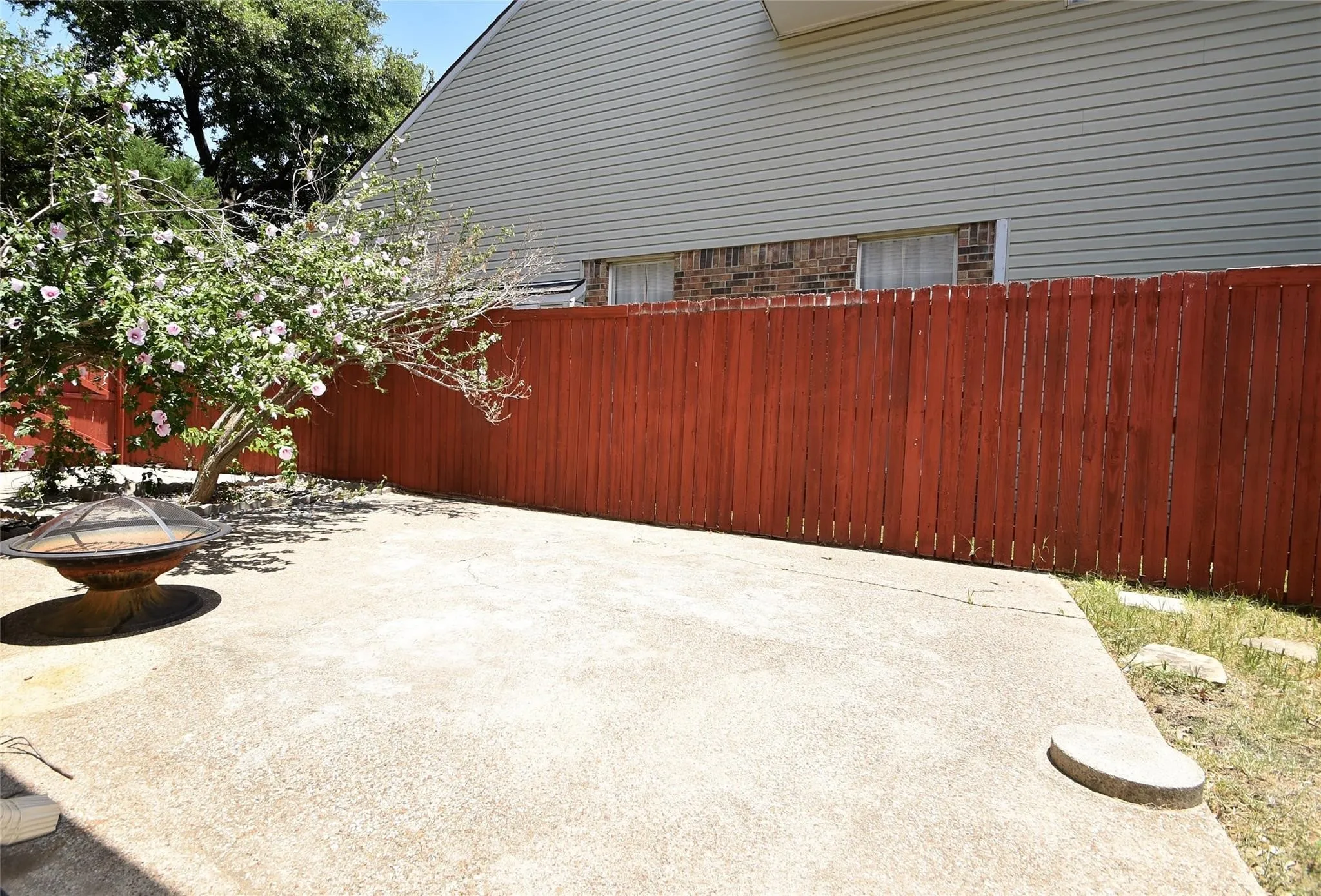 Large stone patio and separate fenced dog run in the backyard.