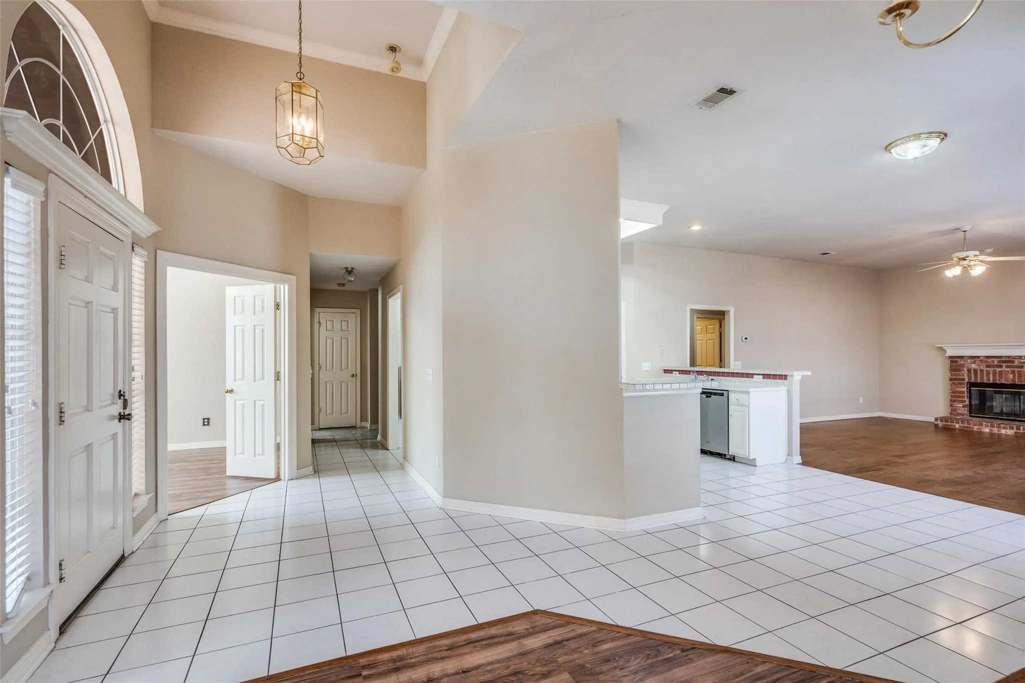 Entryway with vaulted ceilings and a transom window, featuring ceramic tile flooring