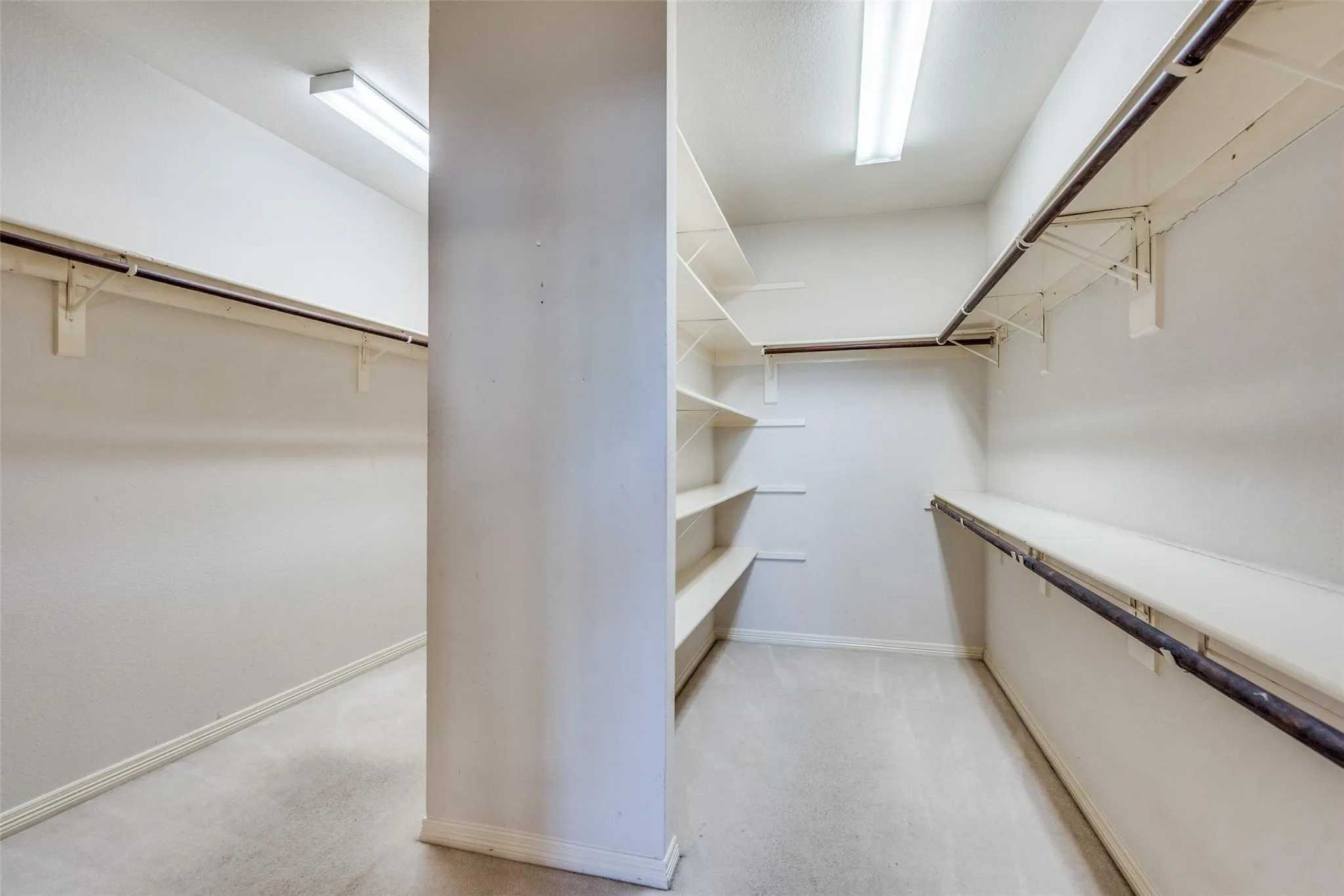 Expansive Oversized walk-in closet featuring built-in shelving, multiple hanging rods, and recessed ceiling lighting