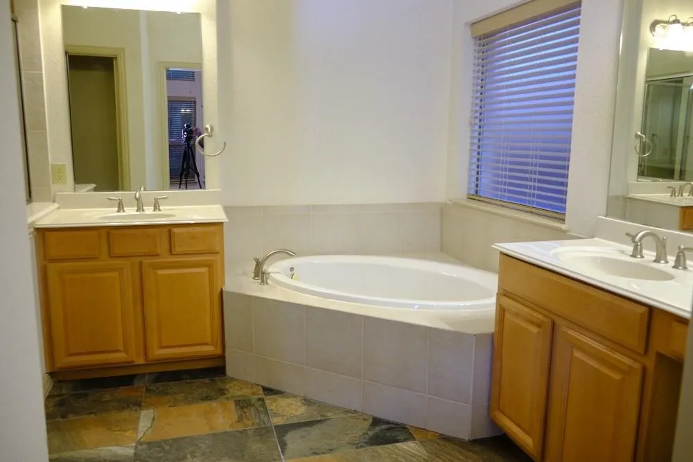 Dual vanity sinks with light-toned cabinetry and integrated mirrors