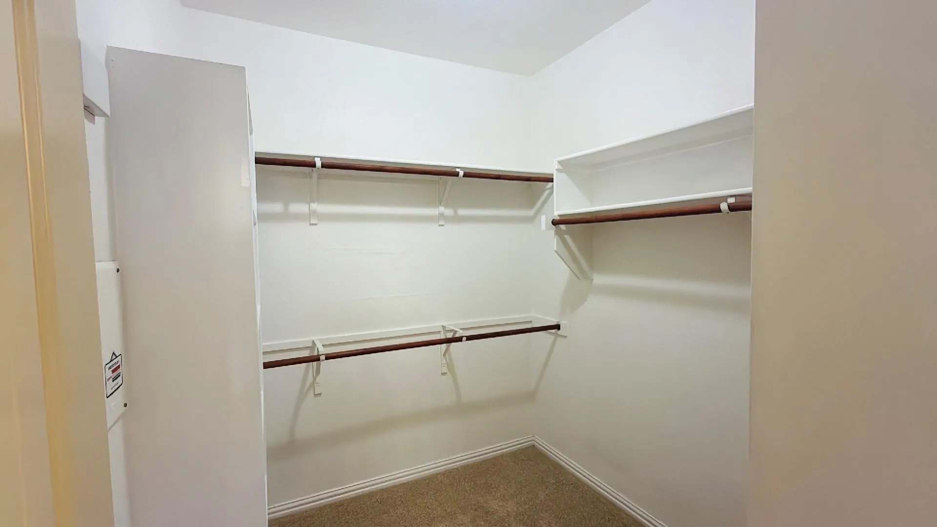 Walk-in closet featuring multiple shelving units and clothing rods