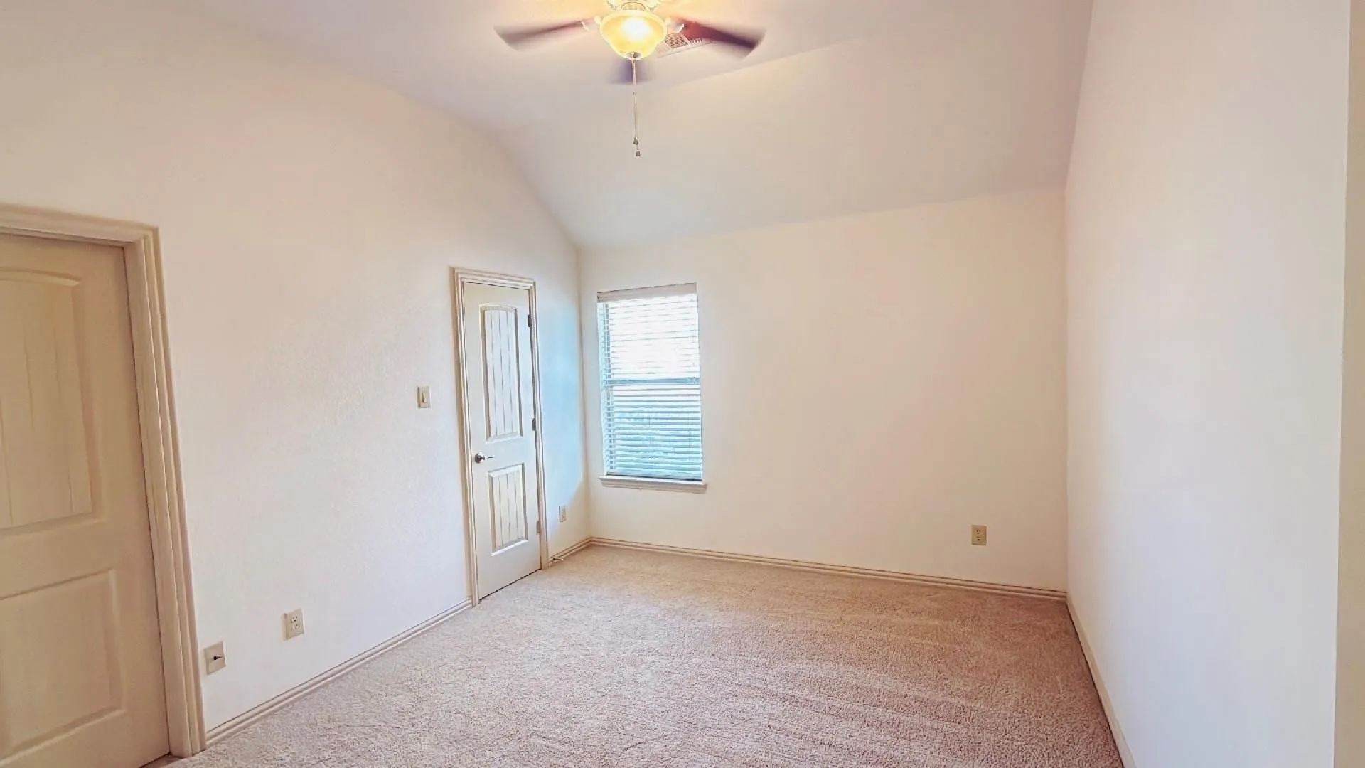 Vaulted ceiling with a ceiling fan, carpet flooring, and a single window with blinds