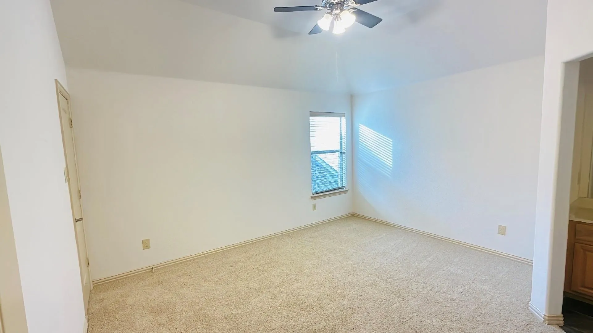 Carpeted flooring, window with blinds, ceiling fan with integrated lighting, and a neutral color palette