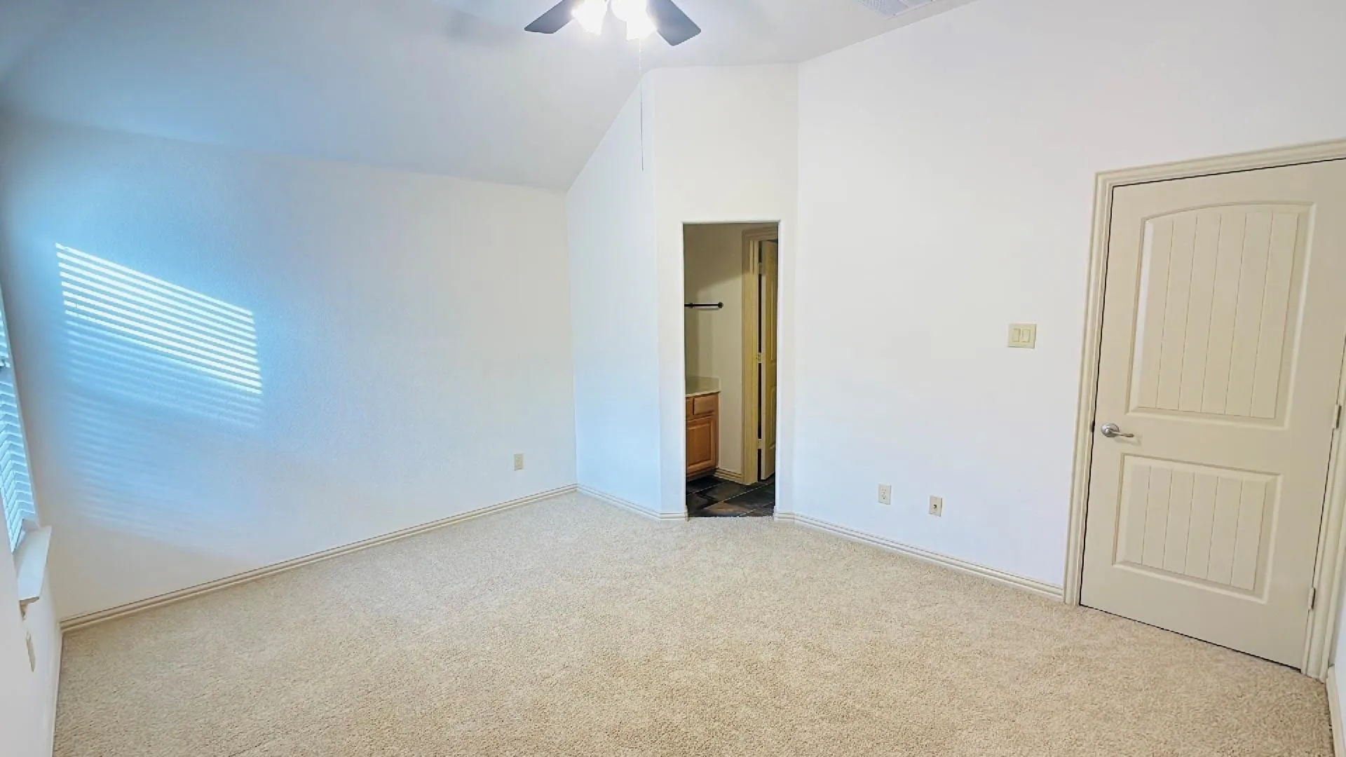 Carpeted flooring with sloped ceiling, ceiling fan, and window with blinds