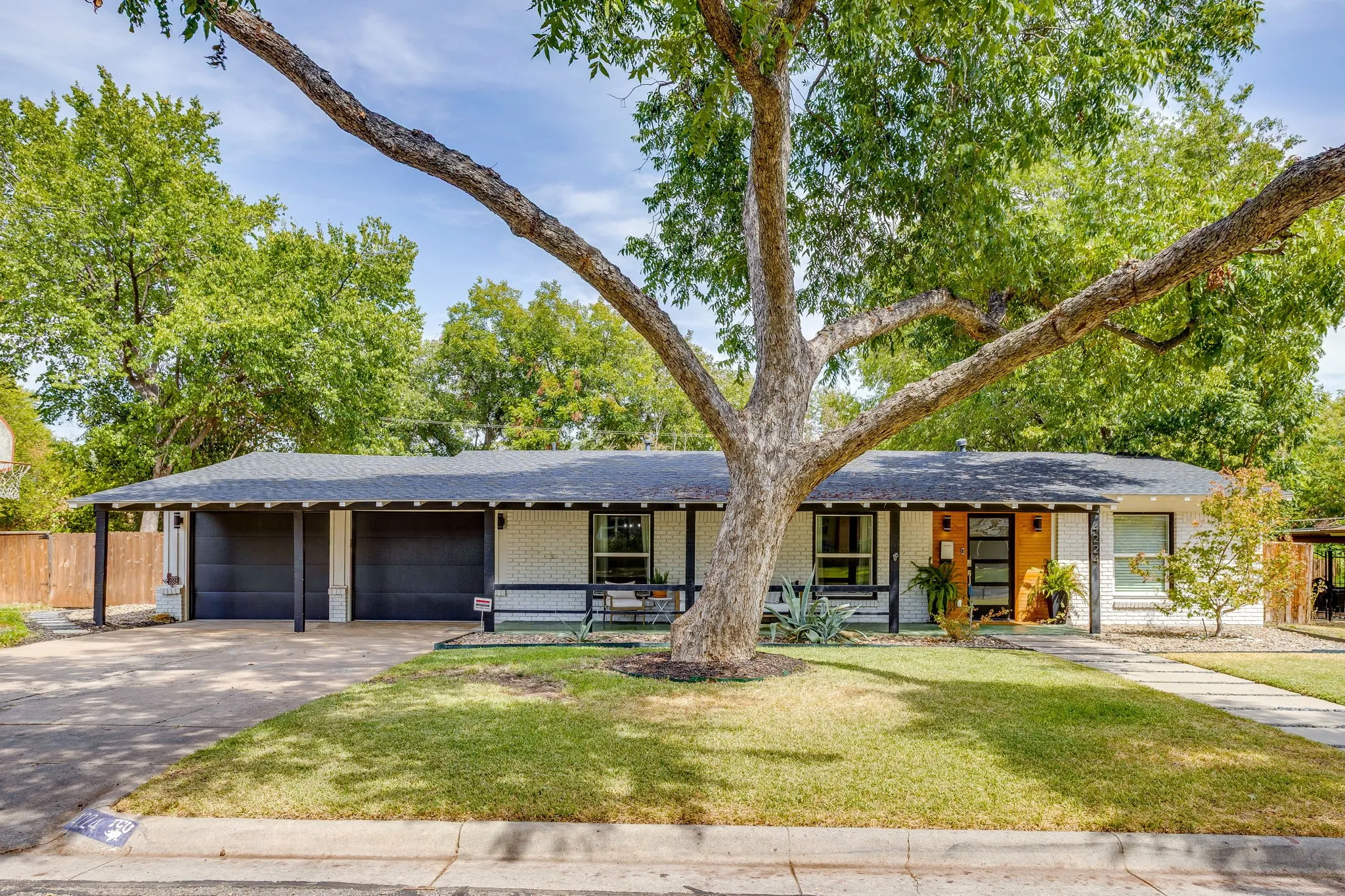 Single-story exterior with a two-car carport, attached two-car garage, and a concrete driveway