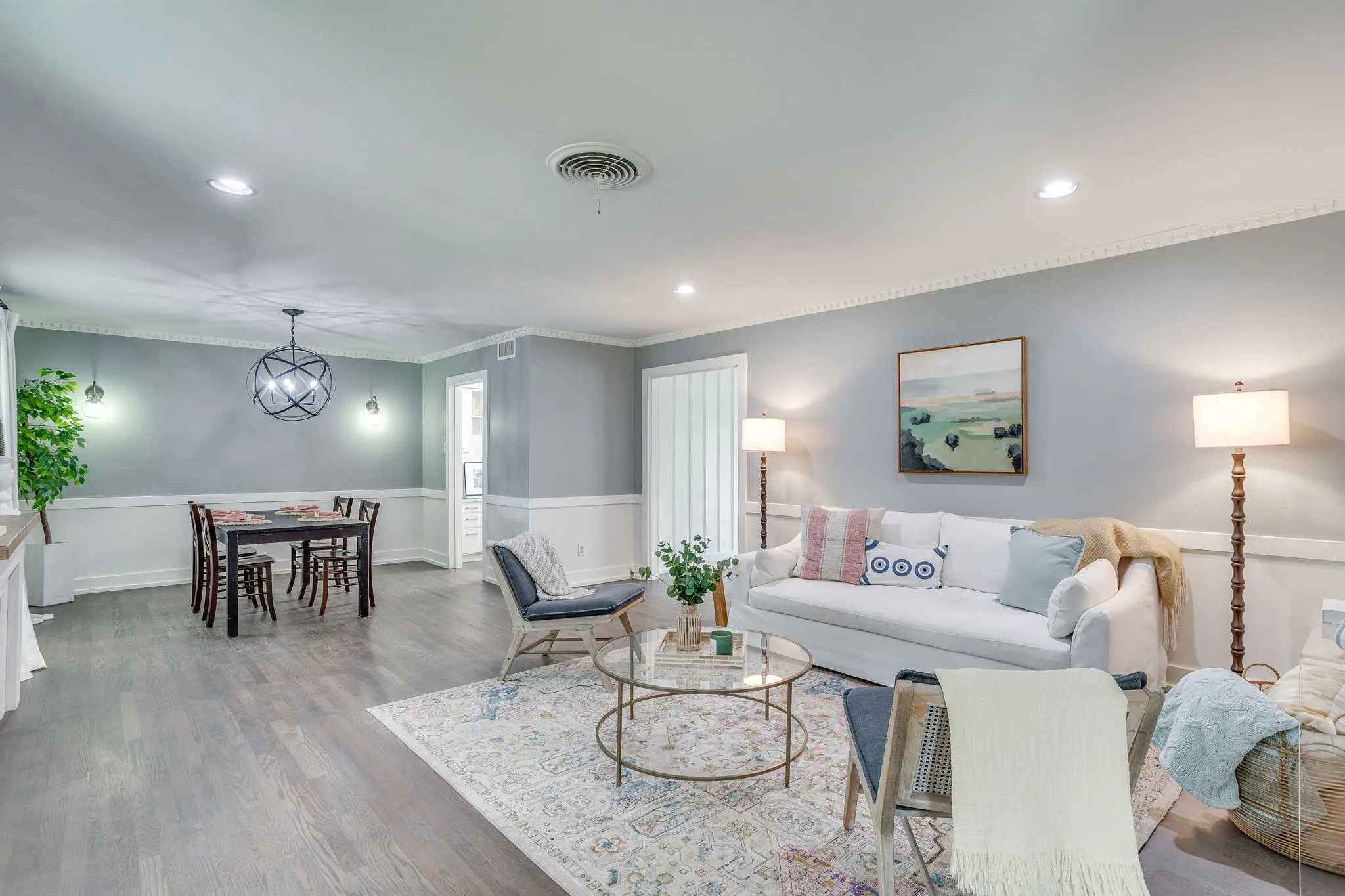 Wood-finish flooring throughout, featuring recessed lighting and crown molding