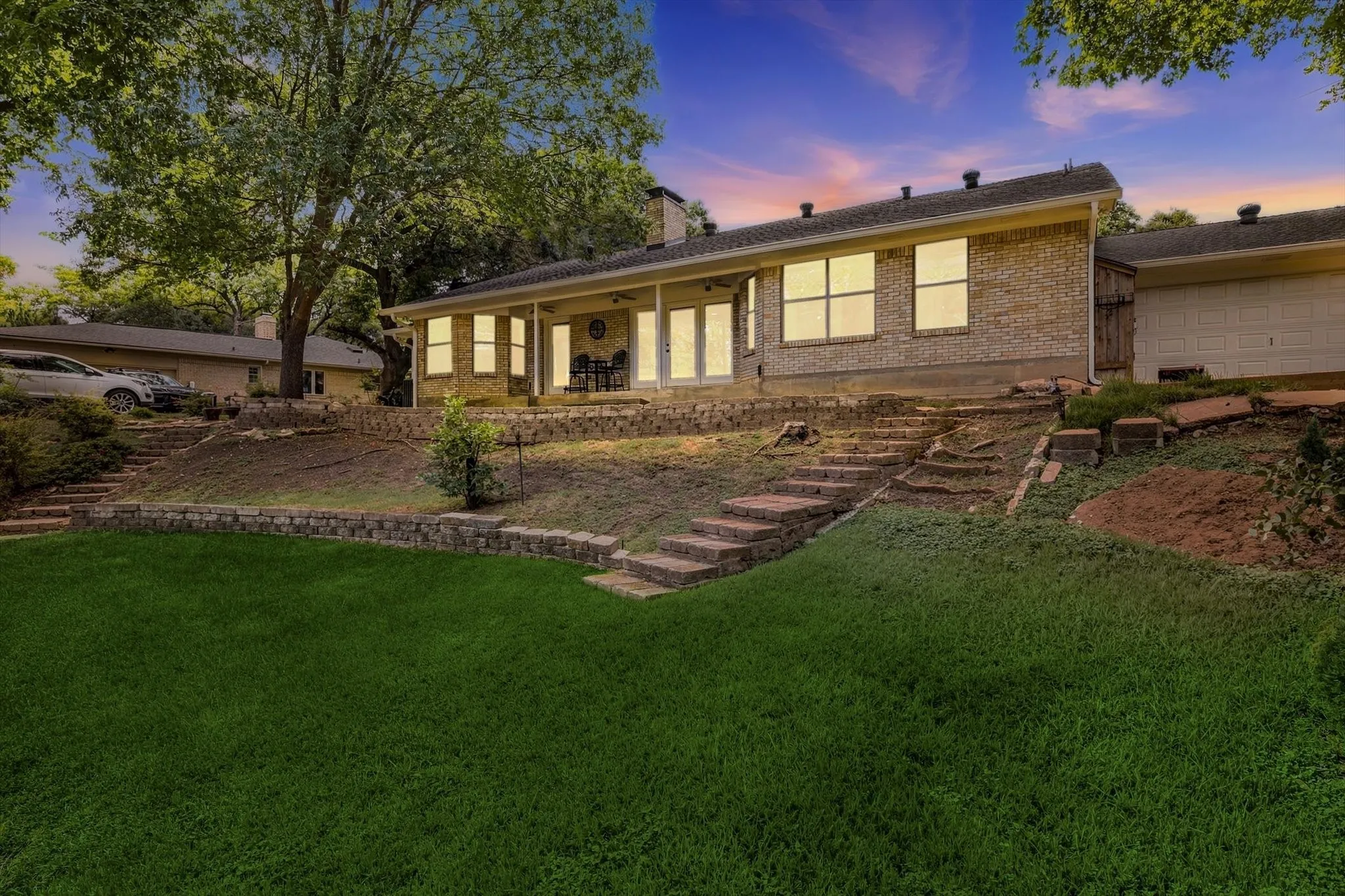 Brick exterior home with a covered patio and multiple windows