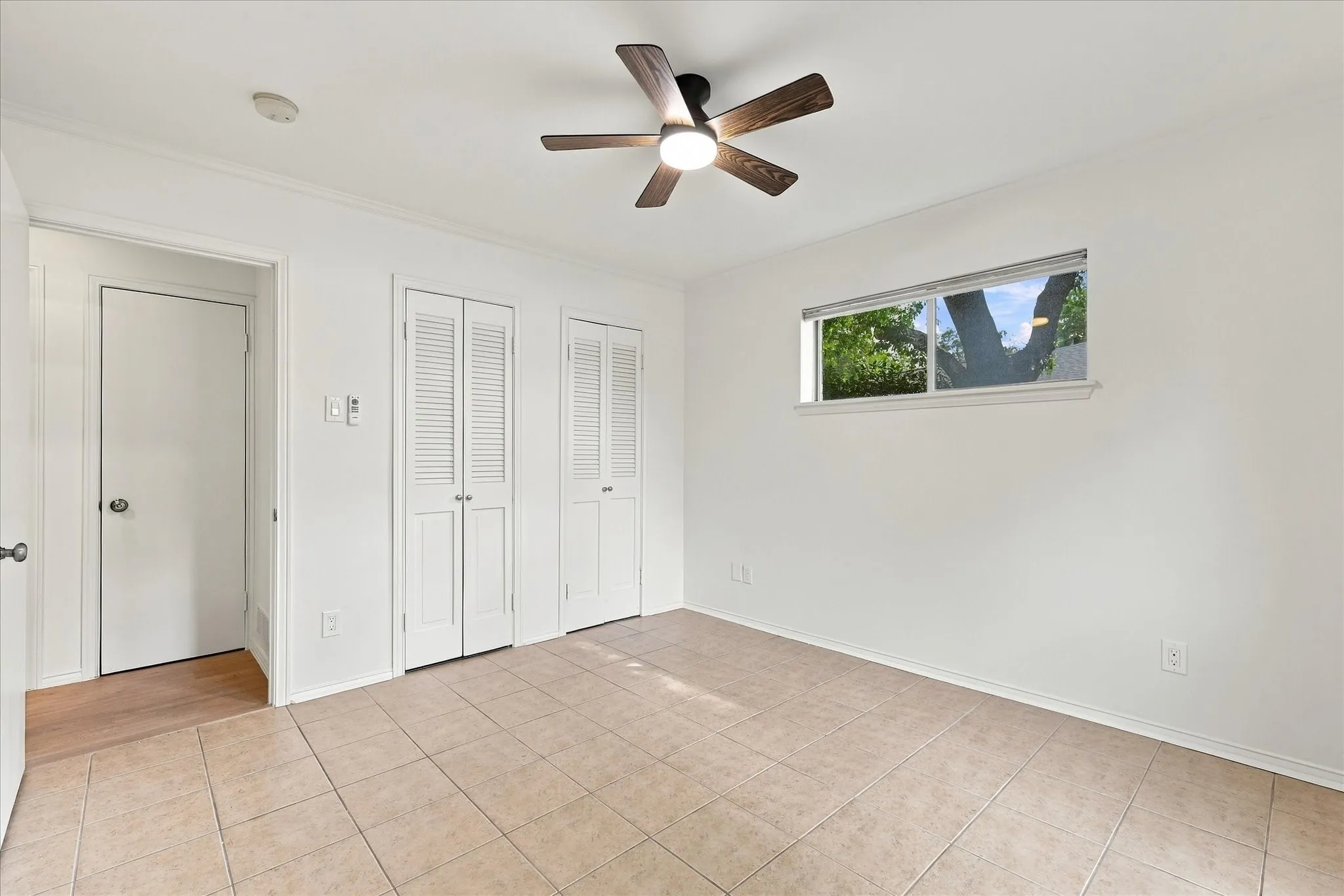 Recessed lighting, ceiling fan with integrated lighting, tiled flooring, horizontal window, and louvered bifold closet doors