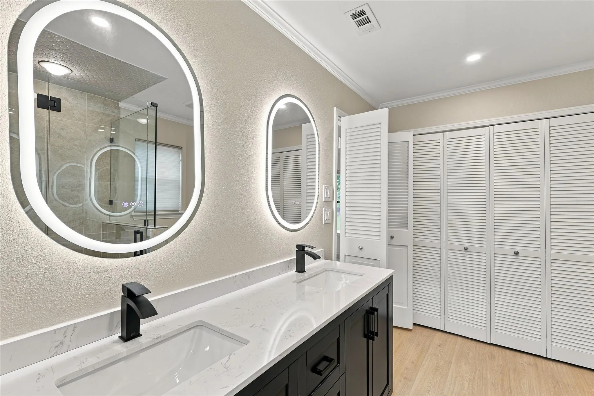 Dual vanity with undermount sinks, stone-finish countertop, and matte black fixtures