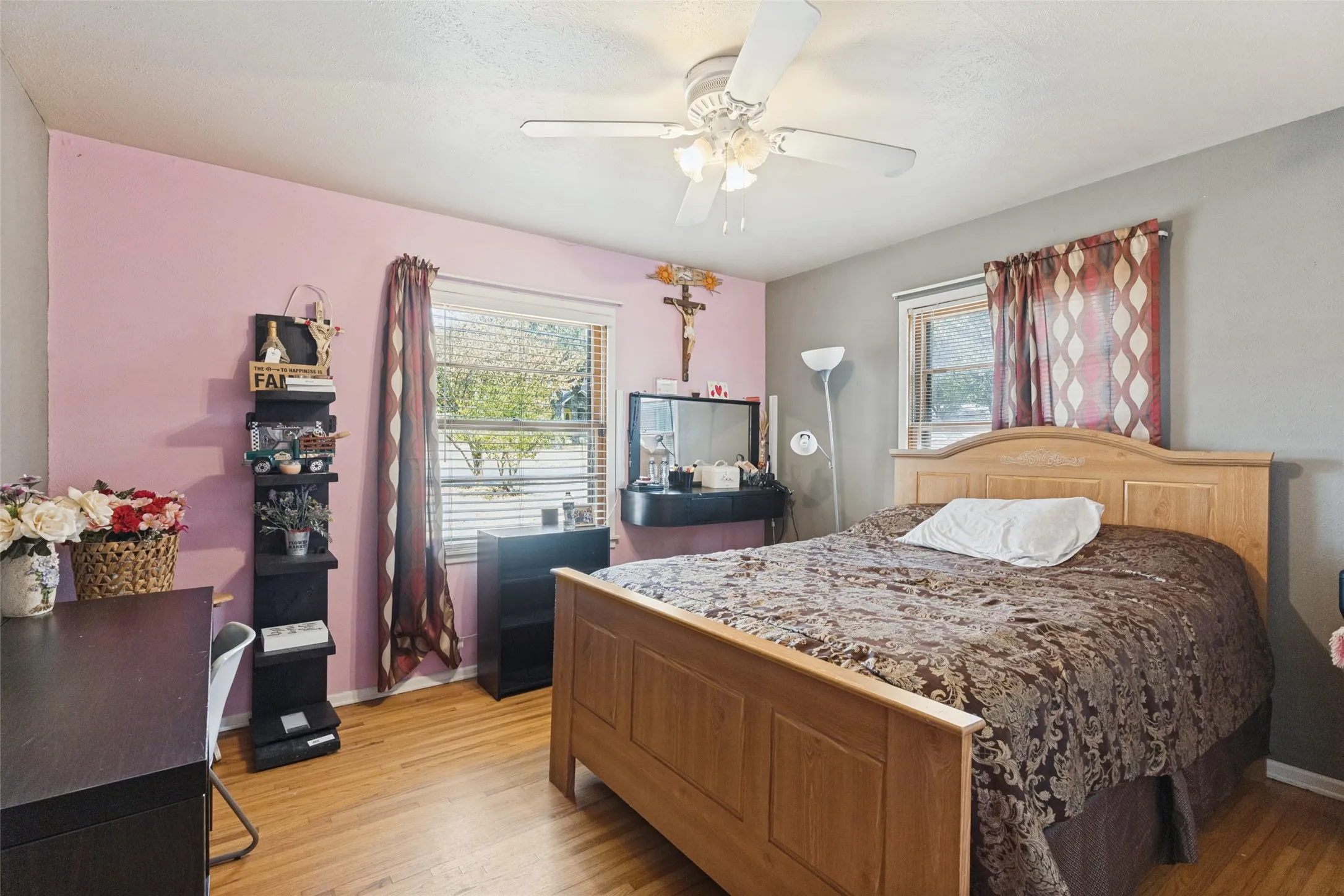 Hardwood-finish flooring, ceiling fan with integrated lighting, and natural light from multiple windows
