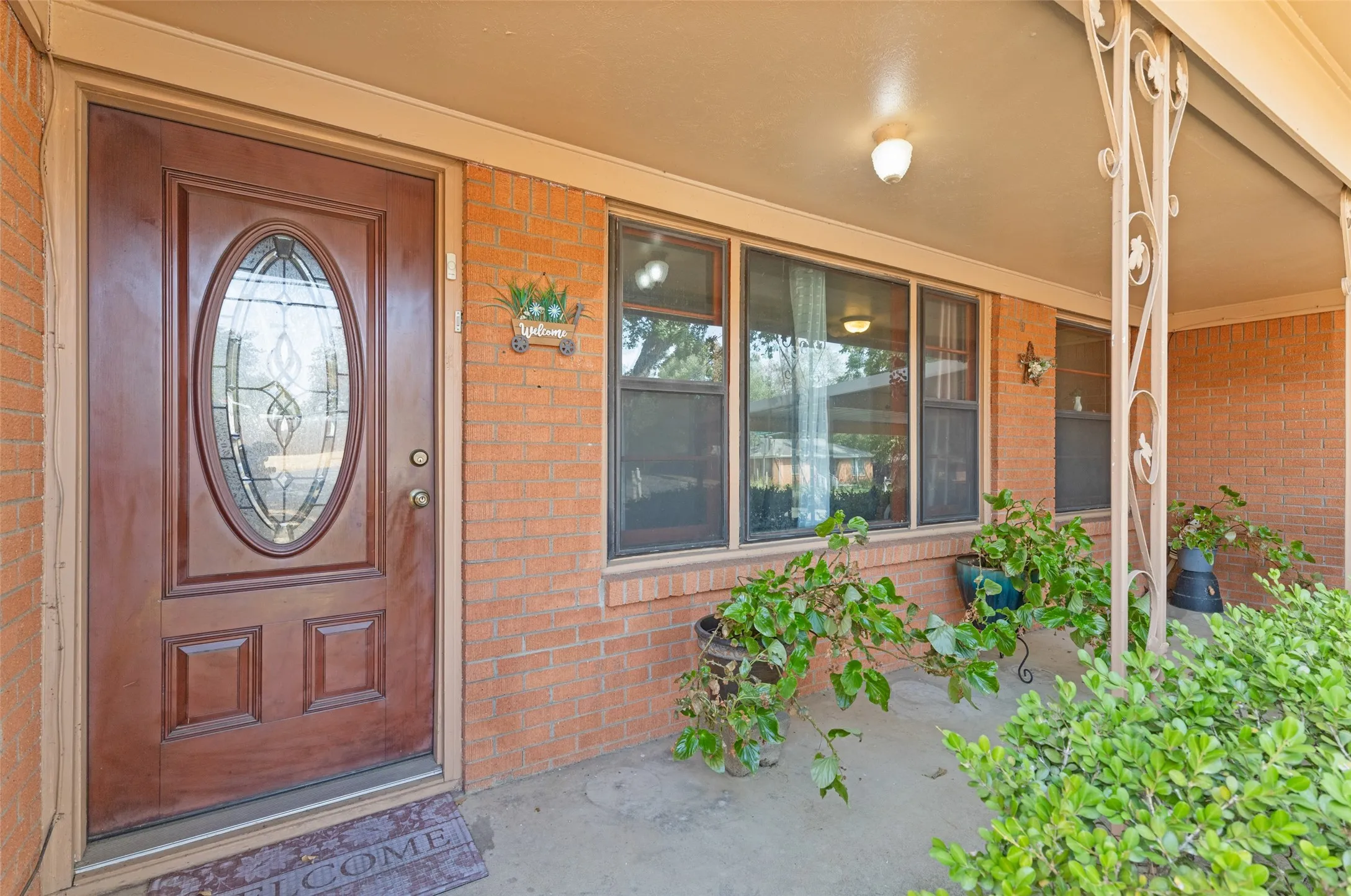 Brick exterior with a covered porch featuring decorative metal columns