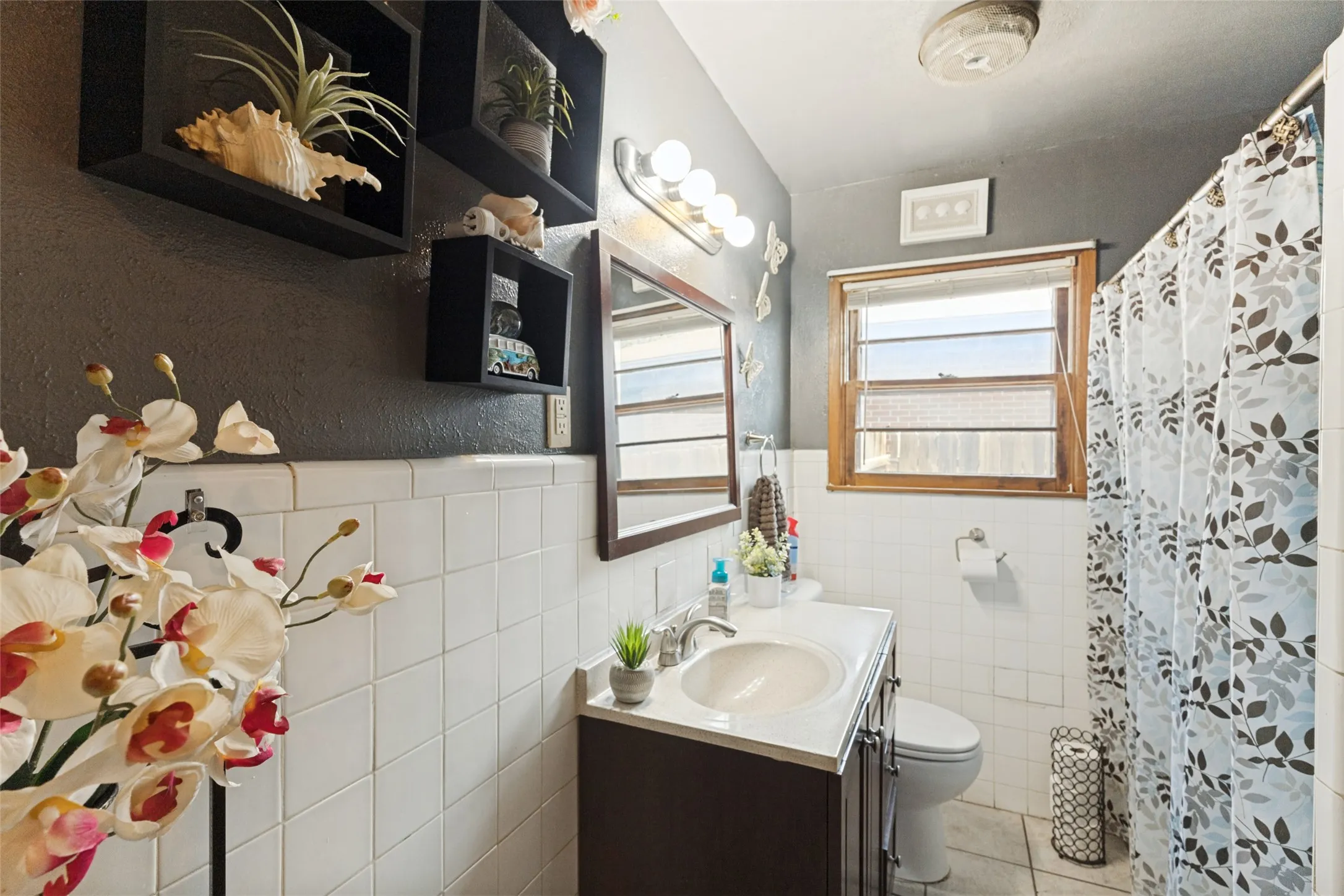 Vanity with integrated sink, wood-framed mirror, and globe lighting