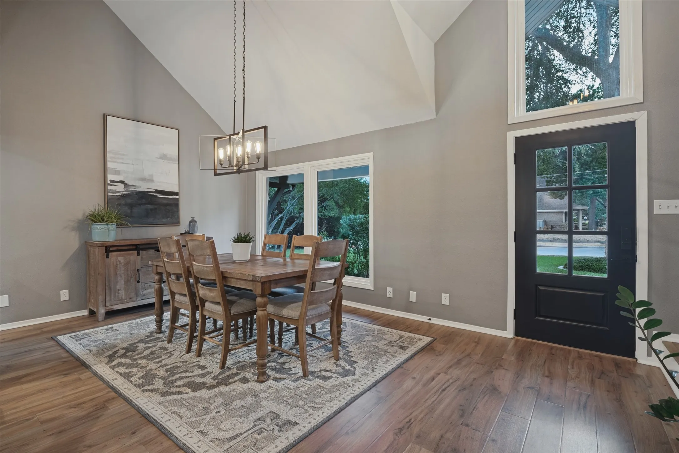 Step inside to a formal dining space that feels light and airy with vaulted ceilings, updated lighting, and an abundance of natural light streaming through large picture windows and the upgraded front door.  Windows throughout this home were replaced in 2020 providing enhanced efficiency, stunning curb appeal, and peaceful tranquility.