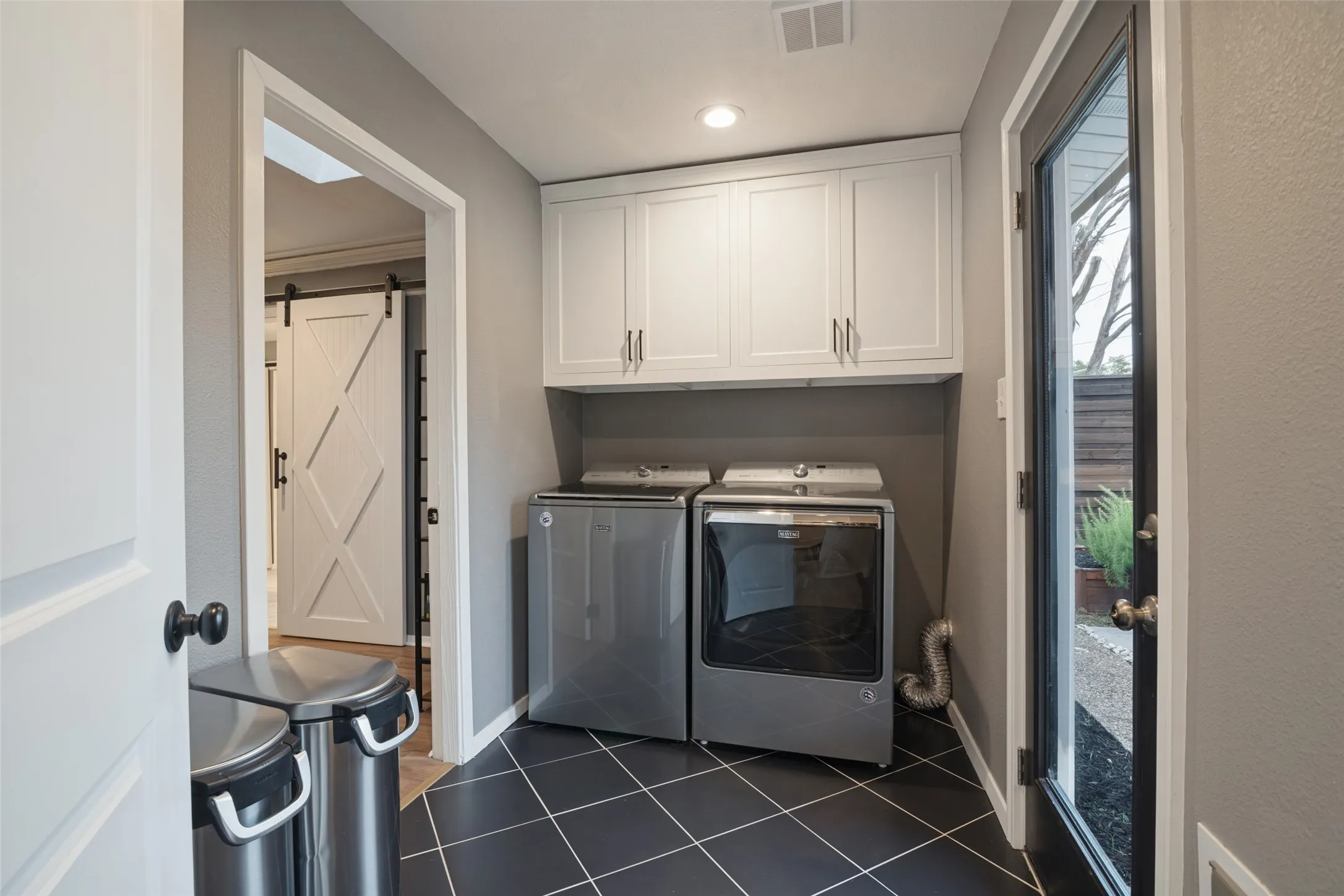 Formerly a sunroom, this space was remodeled in 2022 into additional climate-controlled square footage.  Located just off the breakfast area and connected to the primary bedroom is the spacious utility room with built in cabinets, handsome ceramic tile flooring, and easy access to the patio, spa, and backyard.