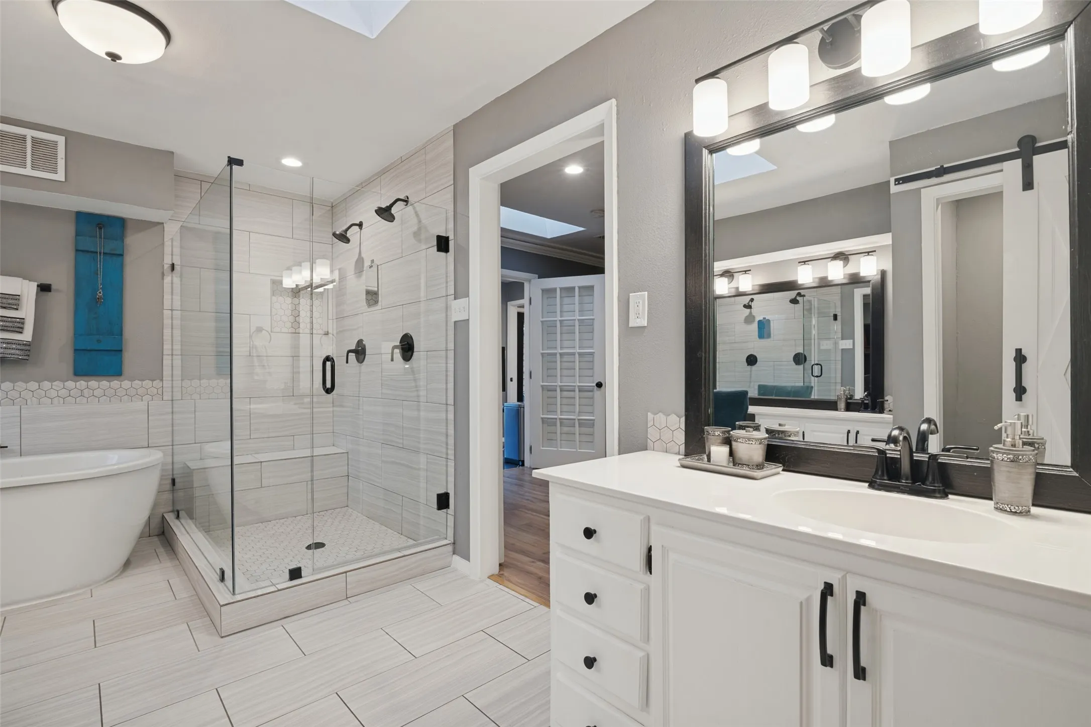Separate vanities offer convenience and extra storage in the downstairs primary bath.
