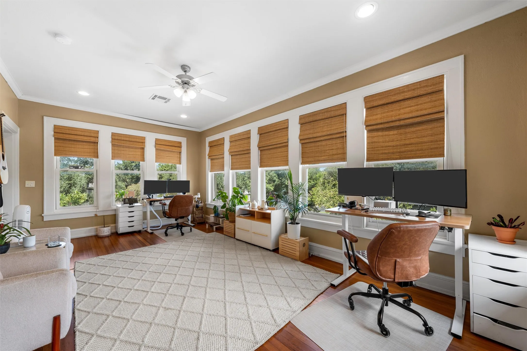 Hardwood flooring, recessed lighting, ceiling fan, multiple windows with blinds, and neutral wall tones