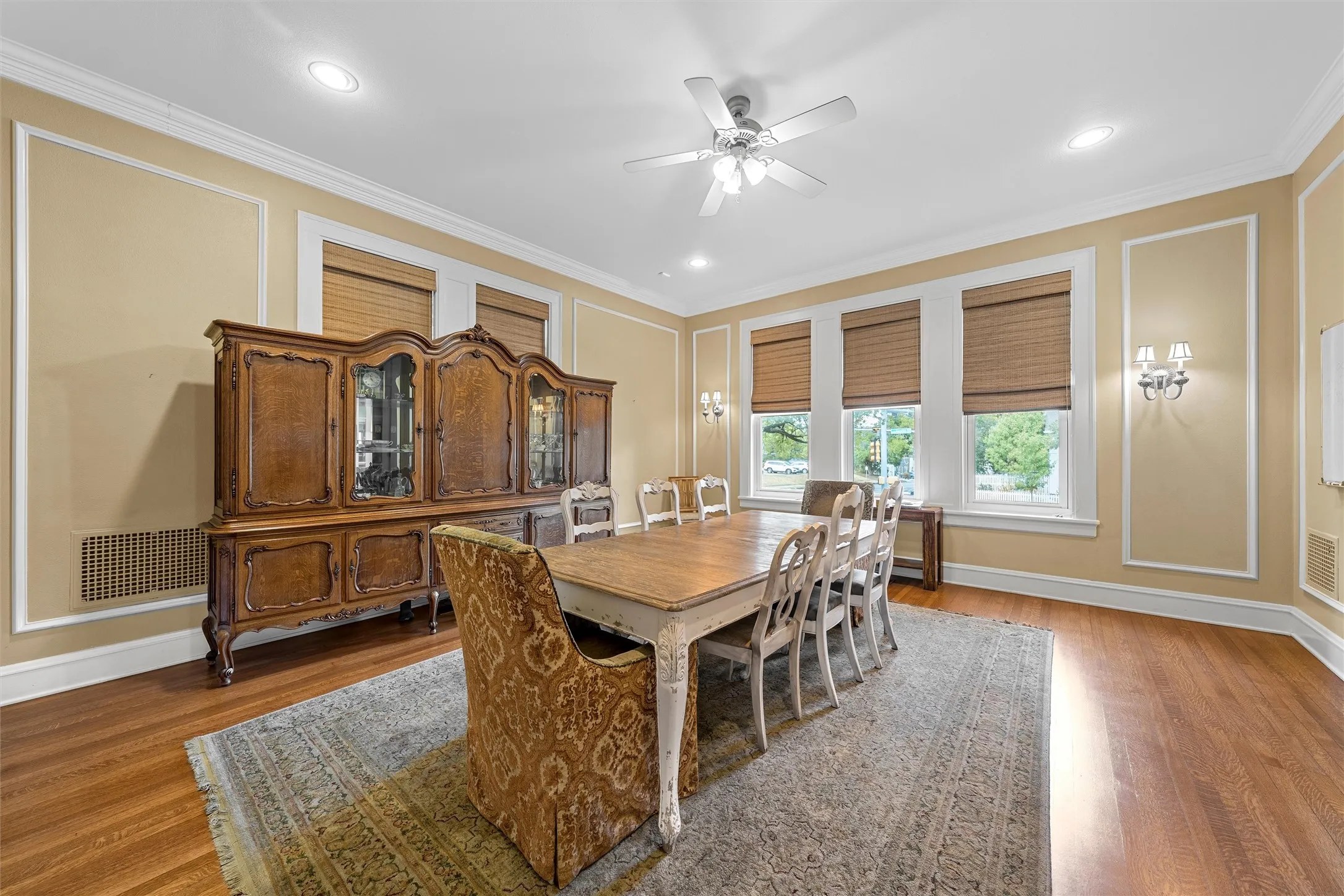 Hardwood flooring, crown molding, decorative wall trim, recessed lighting, and a ceiling fan with light fixture